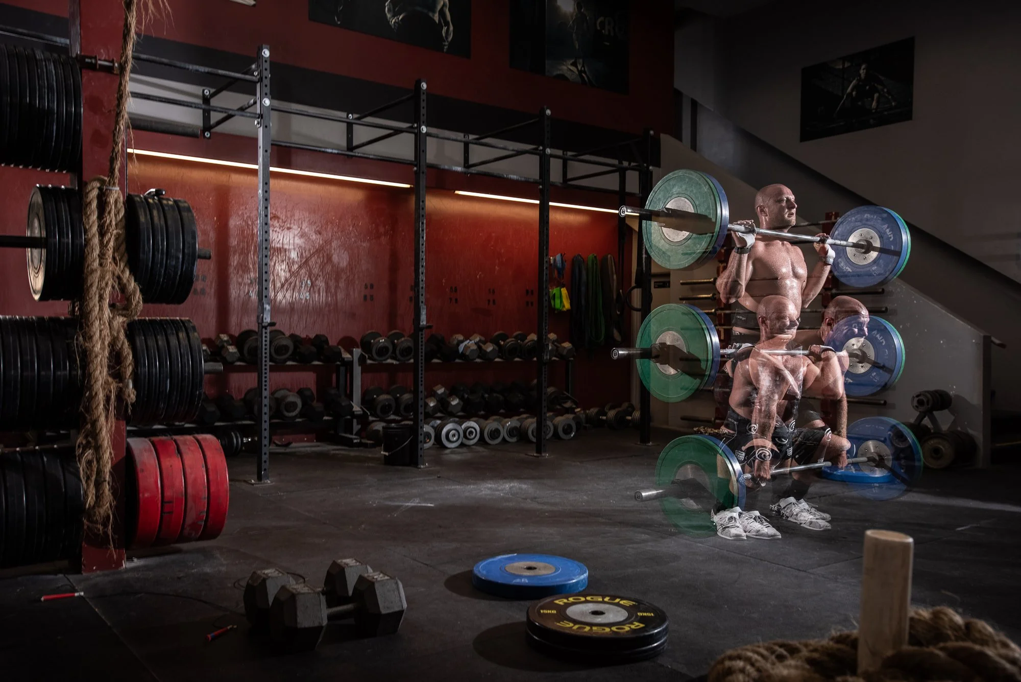 multiple exposure fitness photography of athlete lifting barbell in gym showing movement and strength training