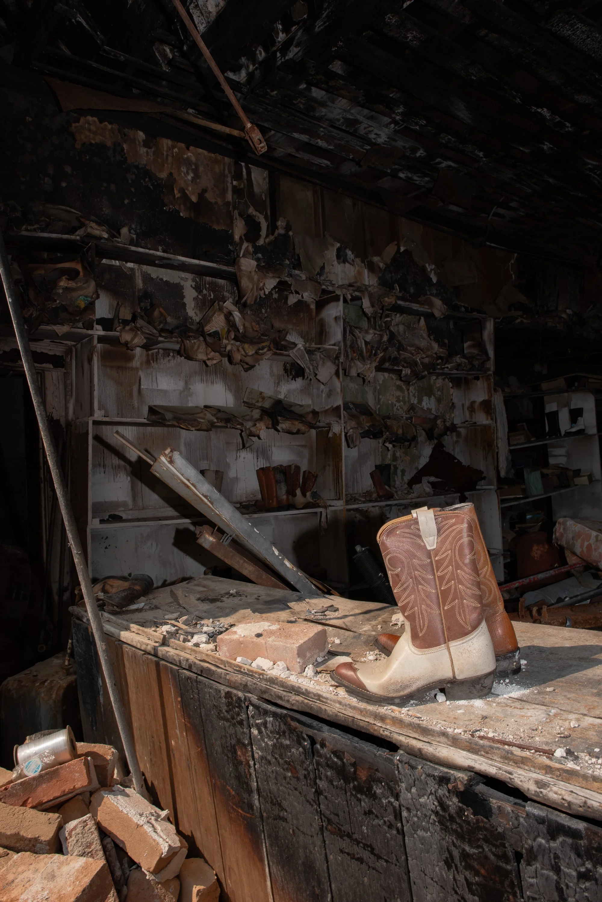 Worn cowboy boots resting on a workbench inside an old Western building