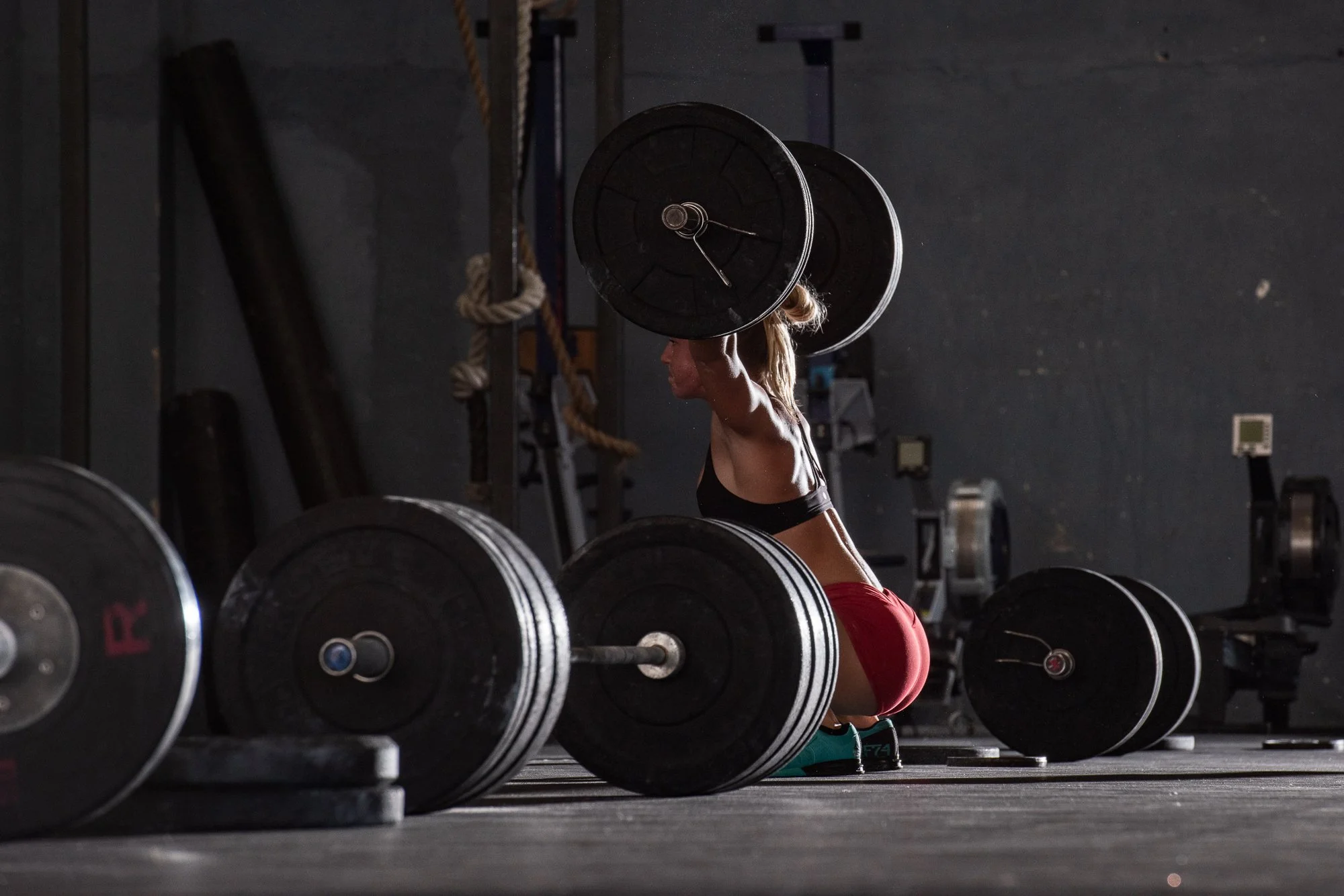 CrossFit athlete holding a loaded barbell overhead during strength training.