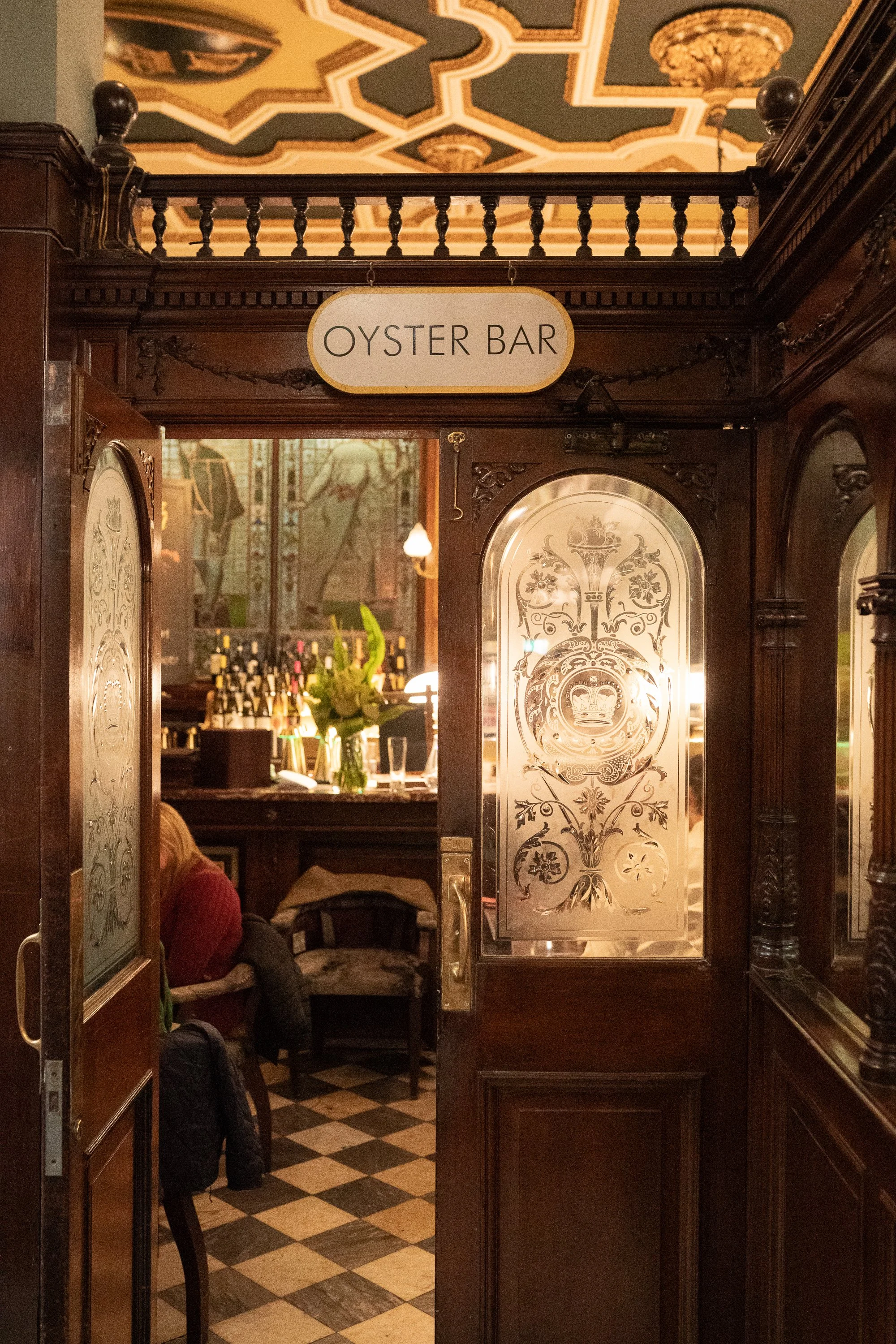 Wooden doorway entrance to the Oyster Bar at Cafe Royal in Edinburgh with etched glass panels