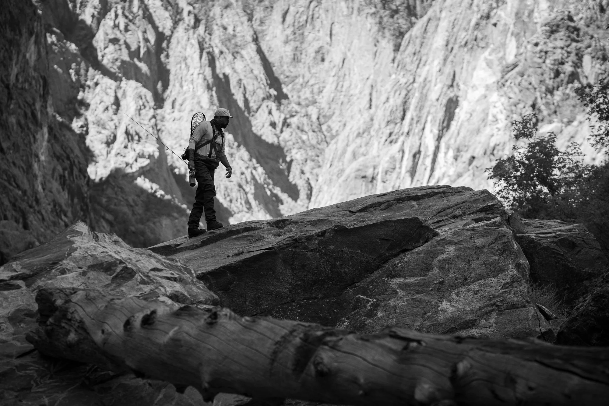 A fly angler crosses large rock formations inside the Black Canyon of the Gunnison.
