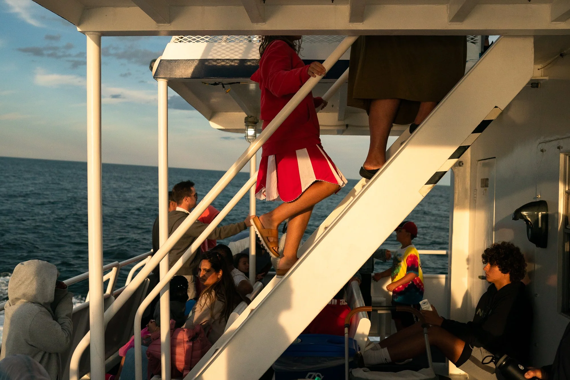People gathered on a whale watching boat off Cape Cod during golden hour light