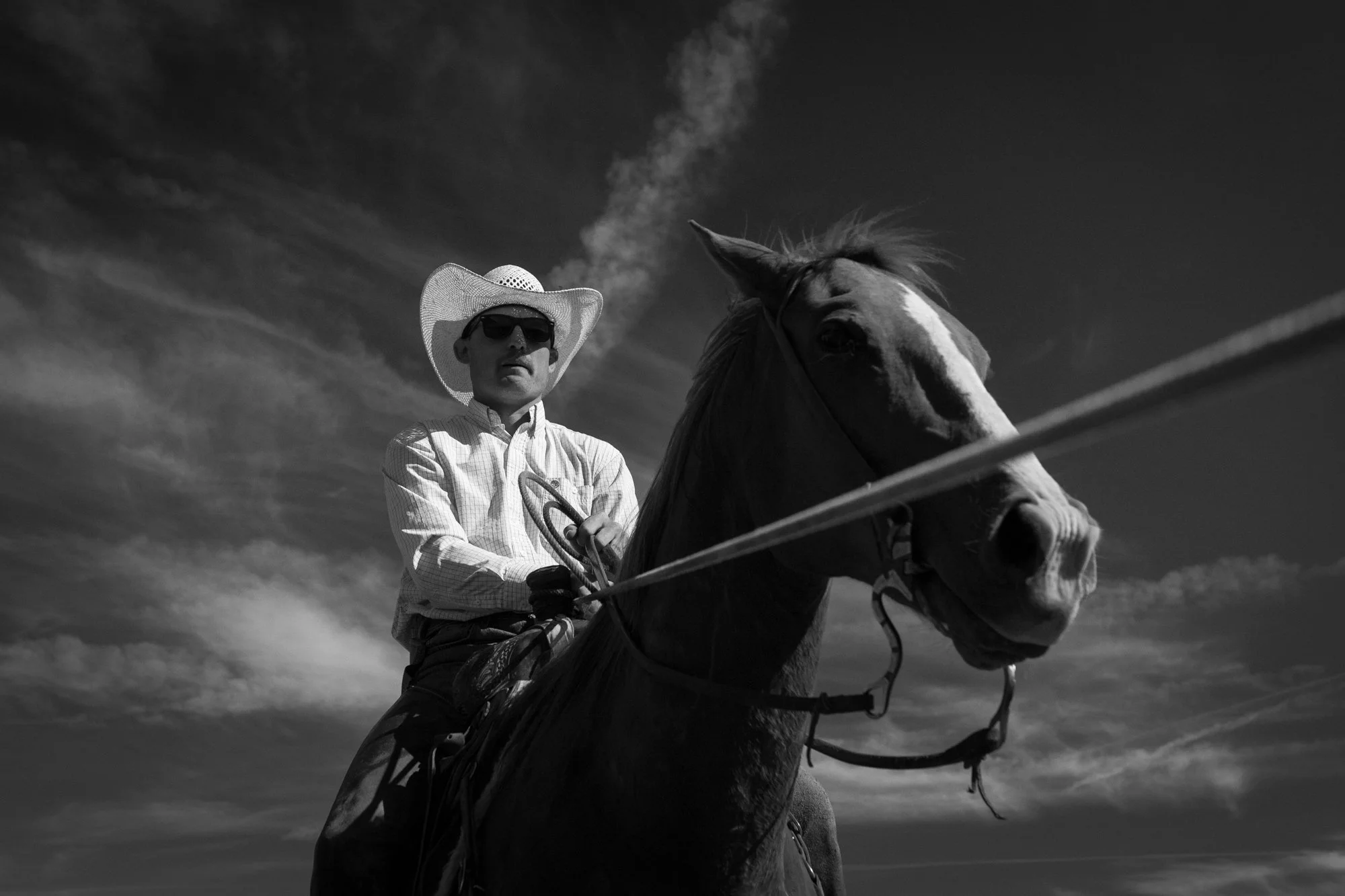 A cowboy wearing sunglasses rides horseback at Silver Spur Ranch in Colorado