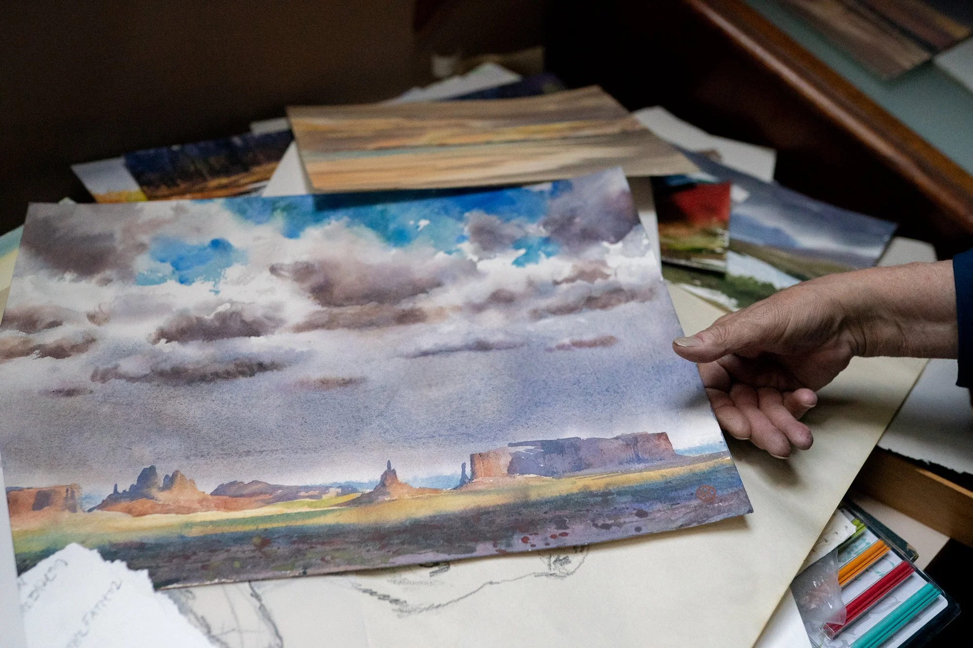 Western landscape watercolor painting featuring mesas and dramatic sky by William Matthews