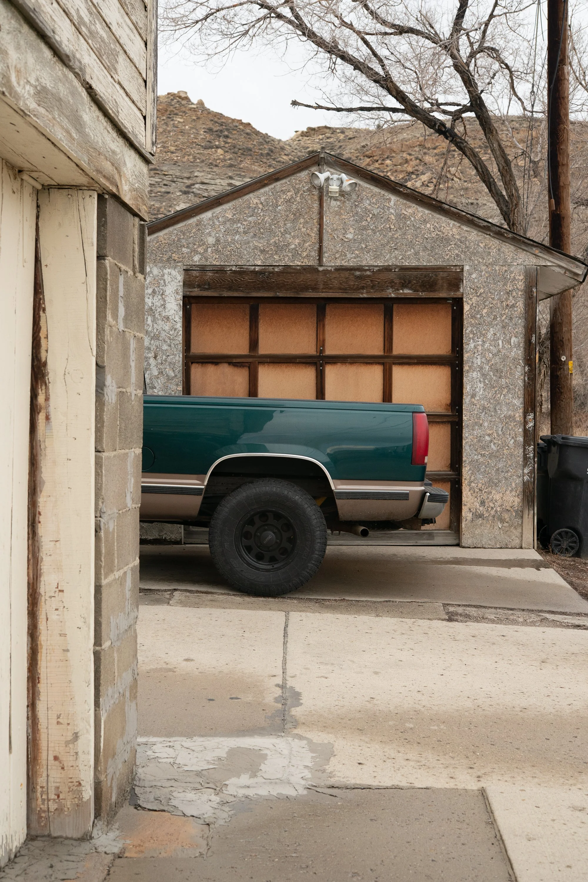 Pickup truck parked beside a garage at the end of a narrow driveway in Rock Springs Wyoming