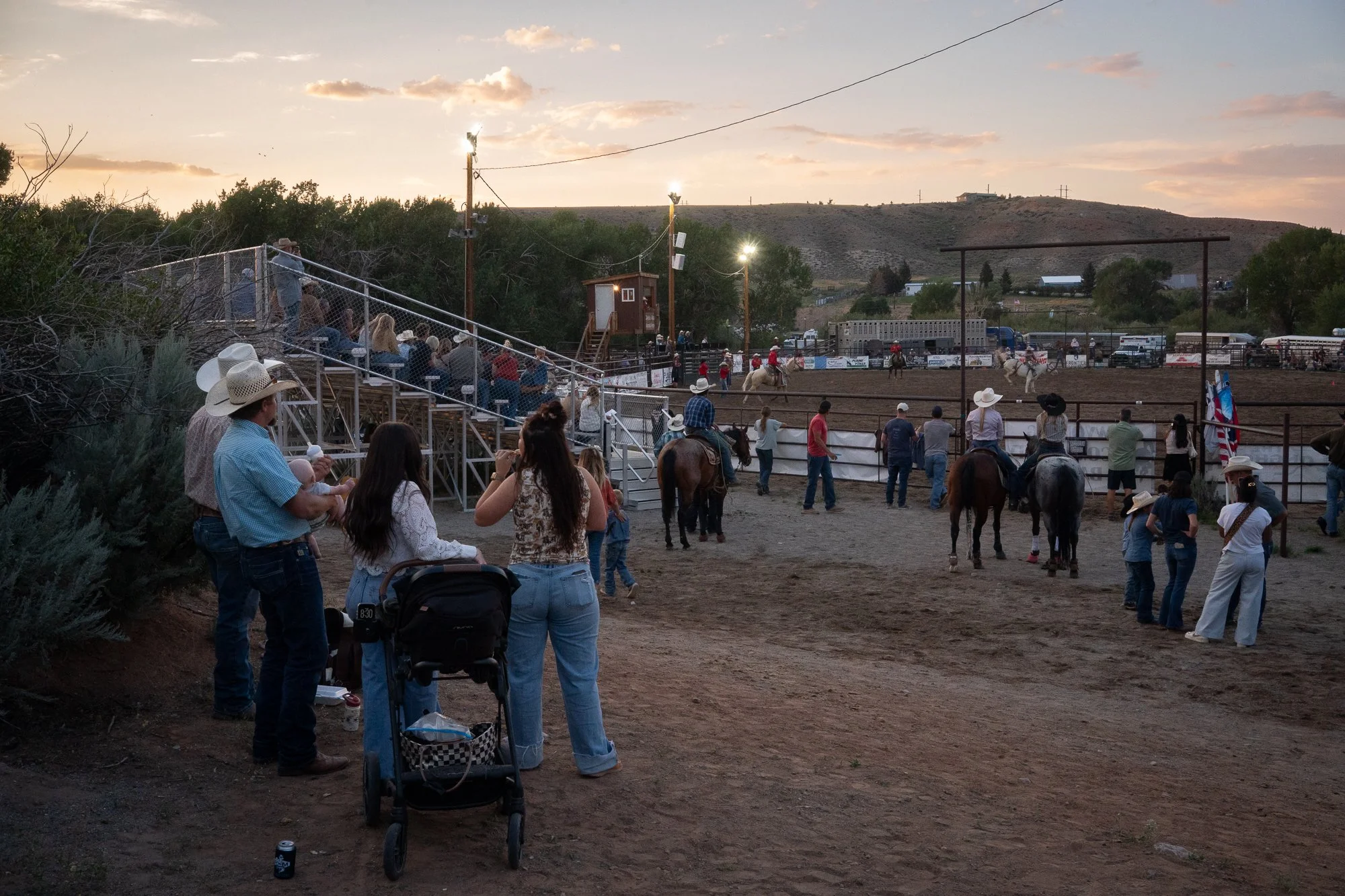 Spectators watch the rodeo from the fence line and grandstands during an evening event in Dubois Wyoming
