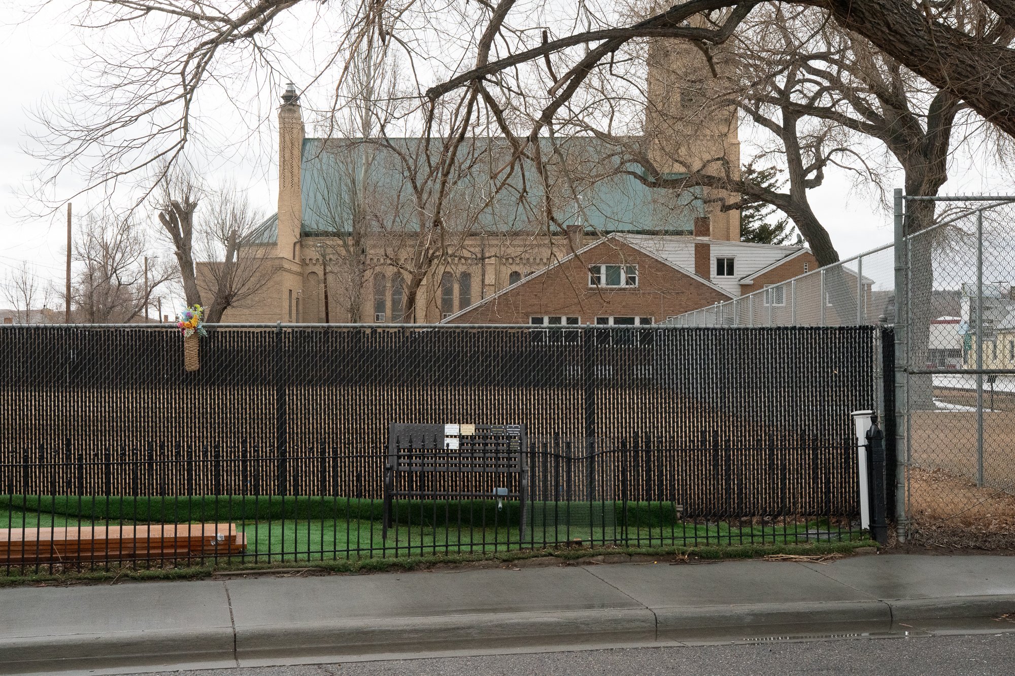 Church building seen behind fence and winter trees in Rock Springs Wyoming