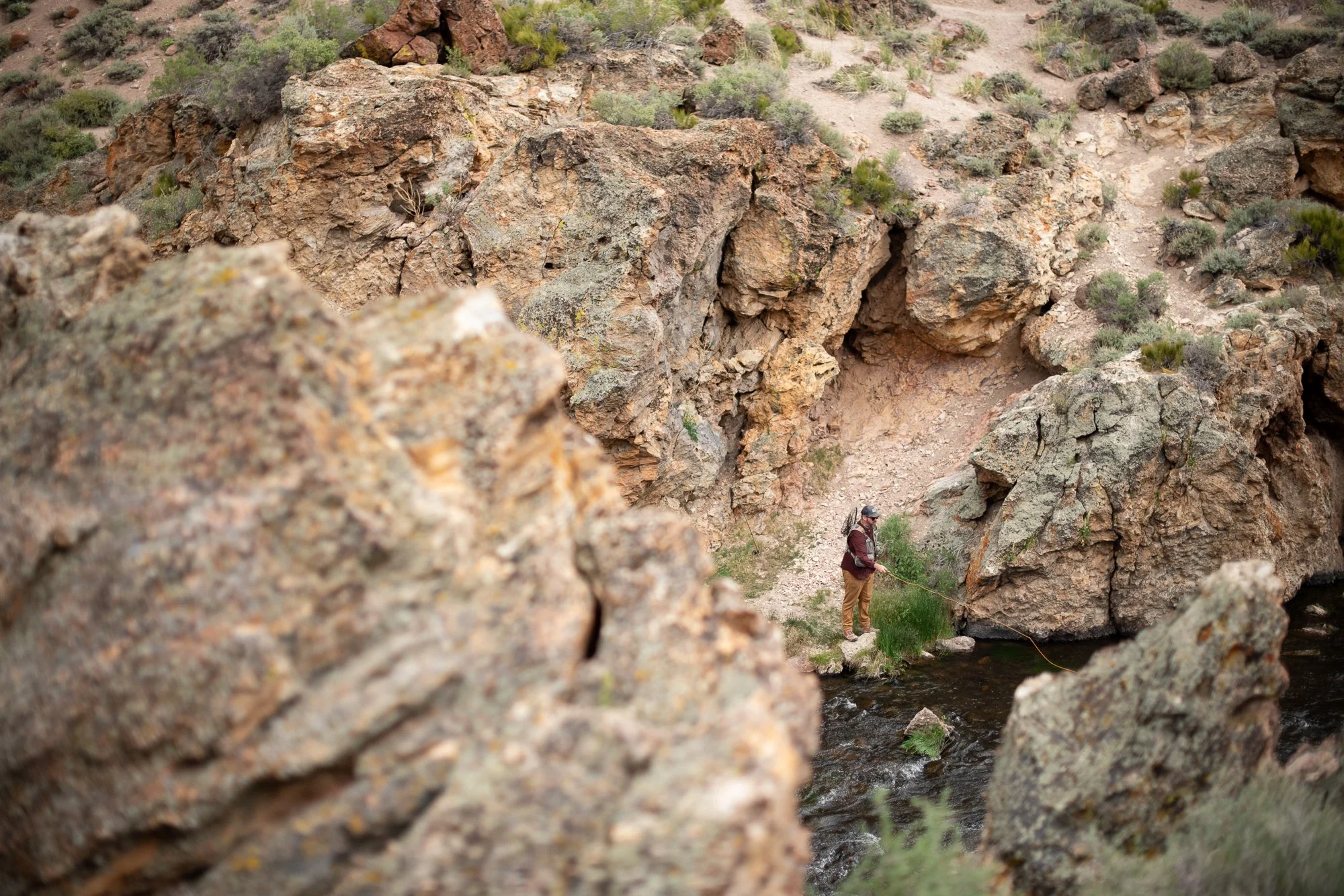 Photograph of a fly fisherman in a rocky canyon near Mammoth, California