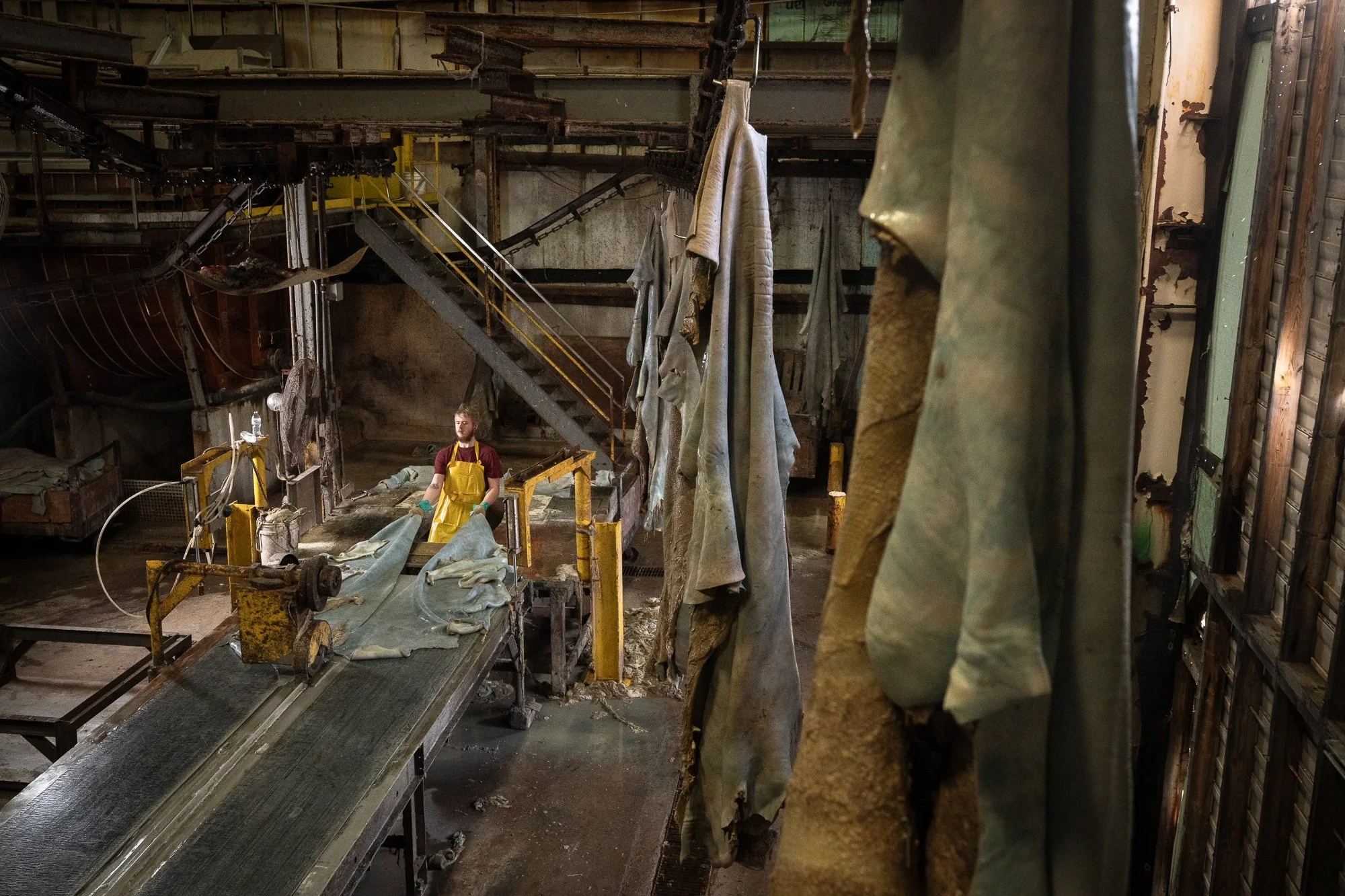 A worker handles leather hides on a conveyor inside the Wickett & Craig tannery in Pennsylvania