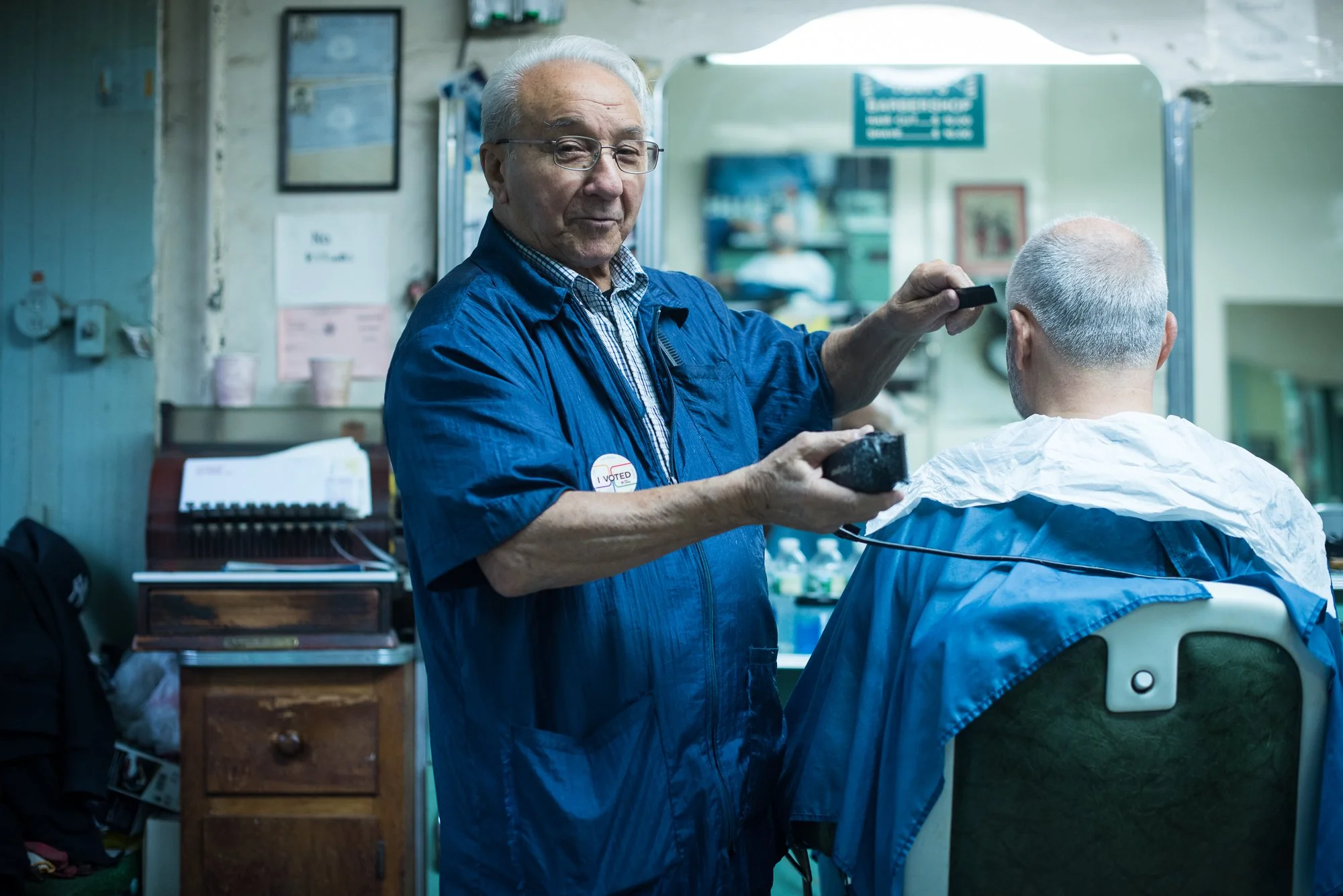 A barber trims a longtime client inside a traditional barbershop in Brooklyn, New York.