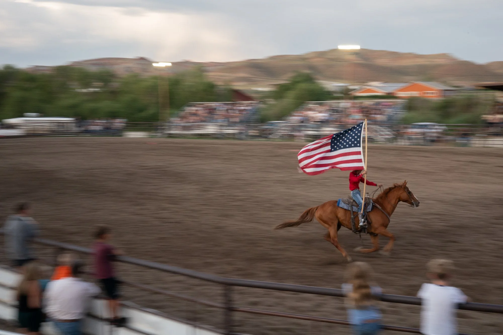 Cowboy on horseback carrying an American flag at a Wyoming rodeo
