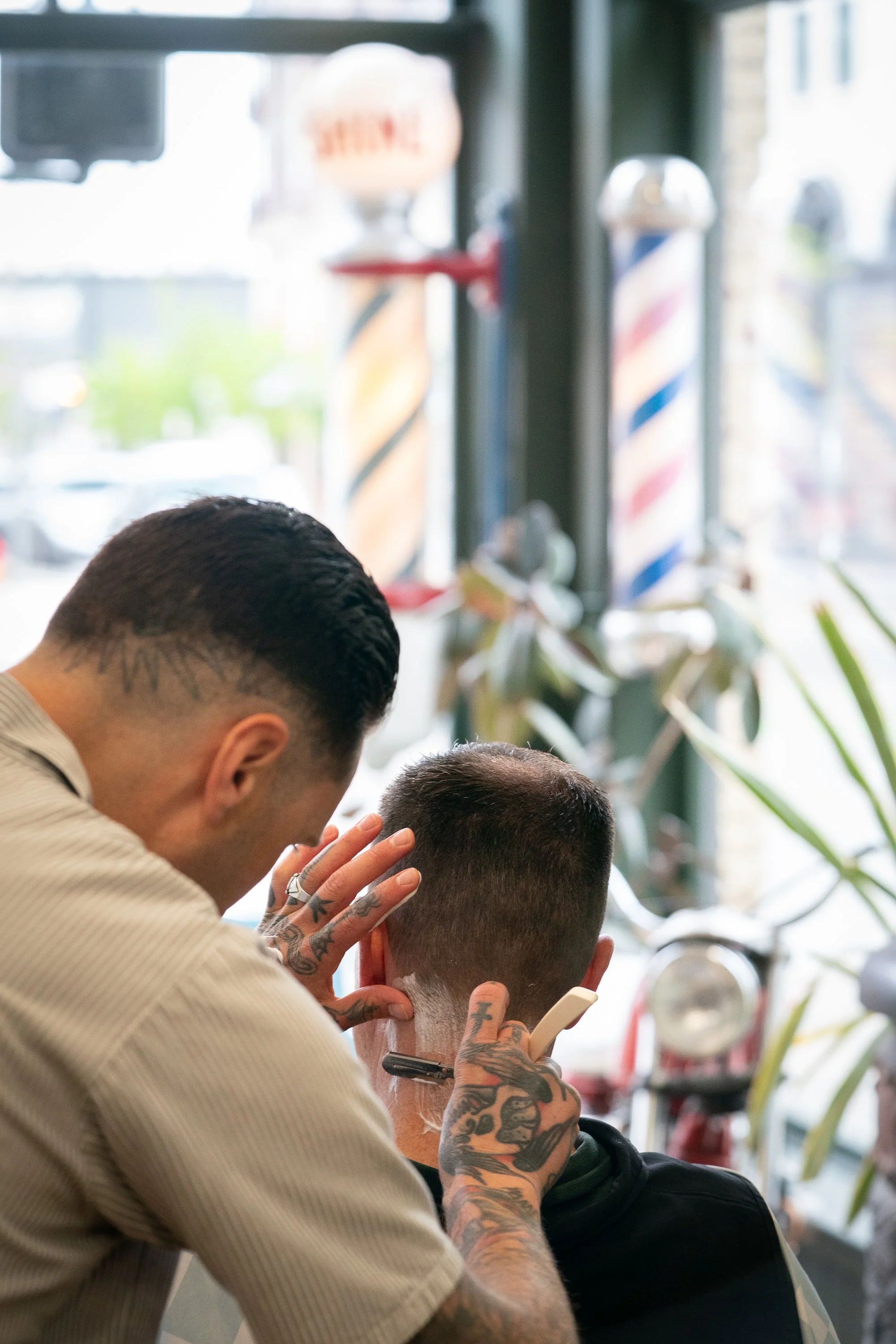 barber using a straight razor for a neck shave inside Belmont Barbershop in Boise Idaho