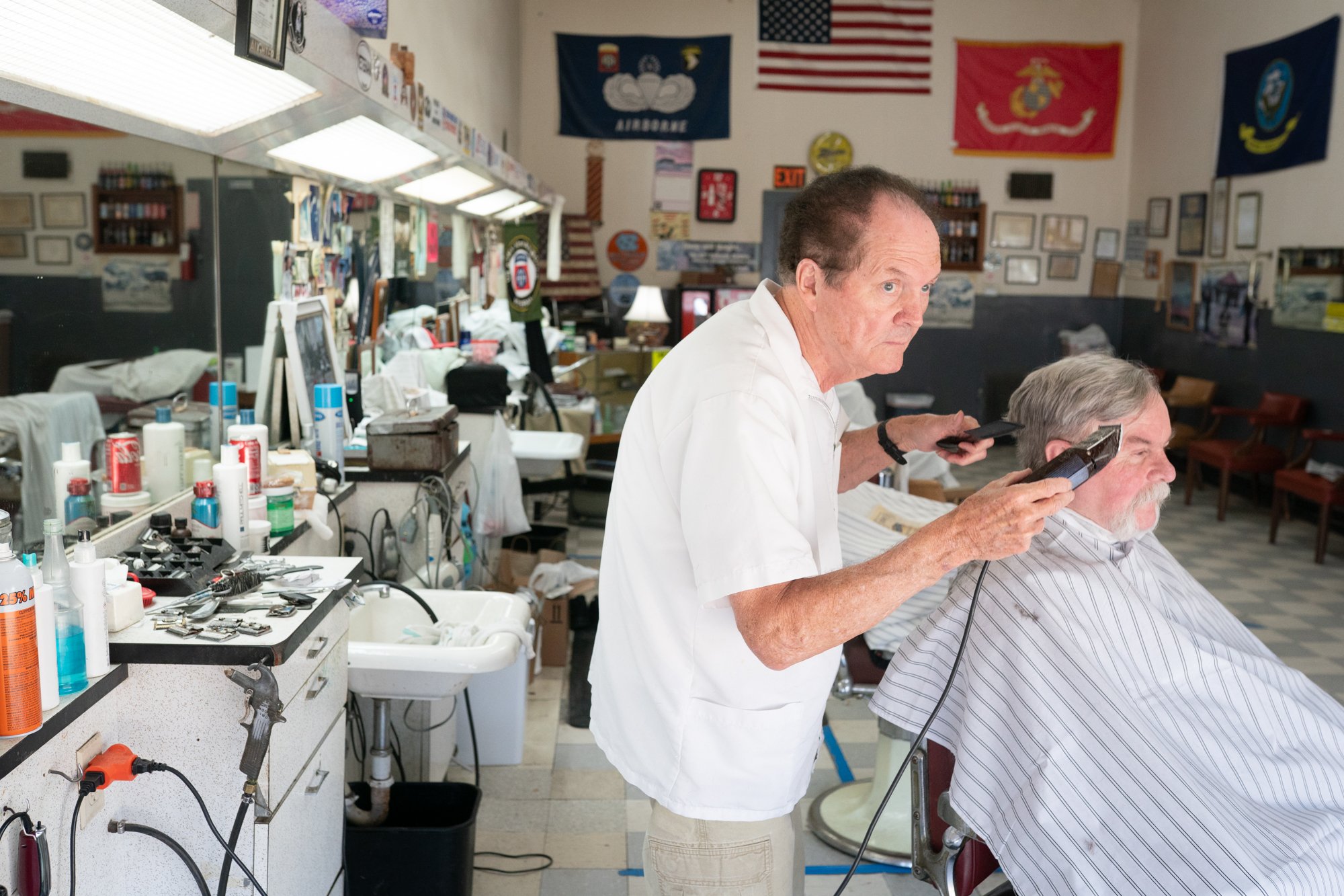 Traditional barbershop interior in North Carolina with a barber cutting a client’s hair using clippers