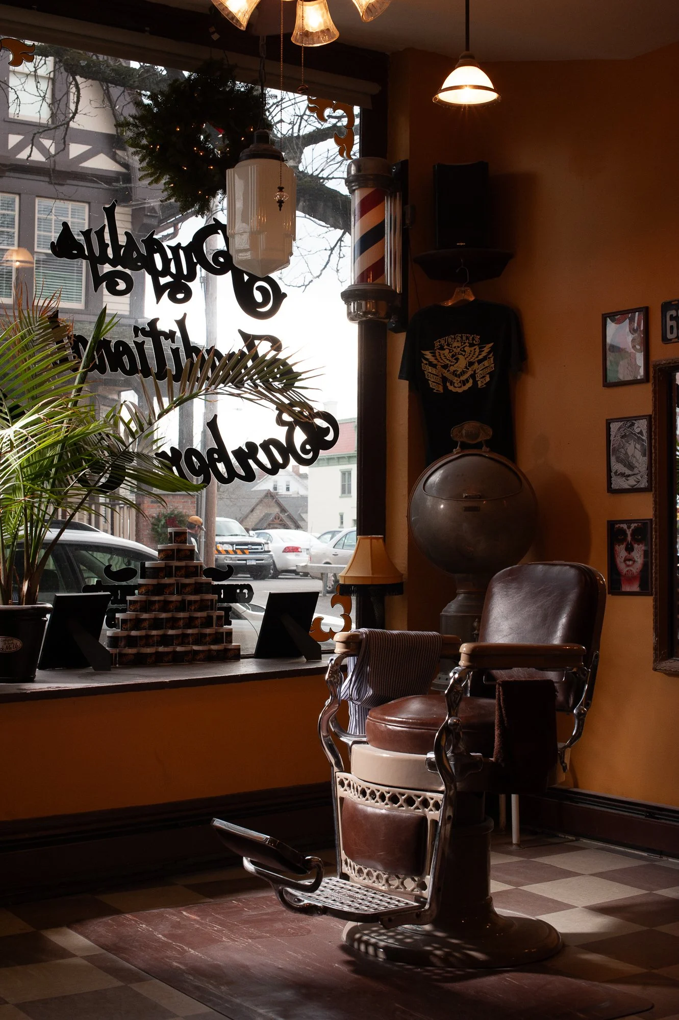 Interior of Pugsly's SideShow Barbershop showing a vintage barber chair and decorated window.