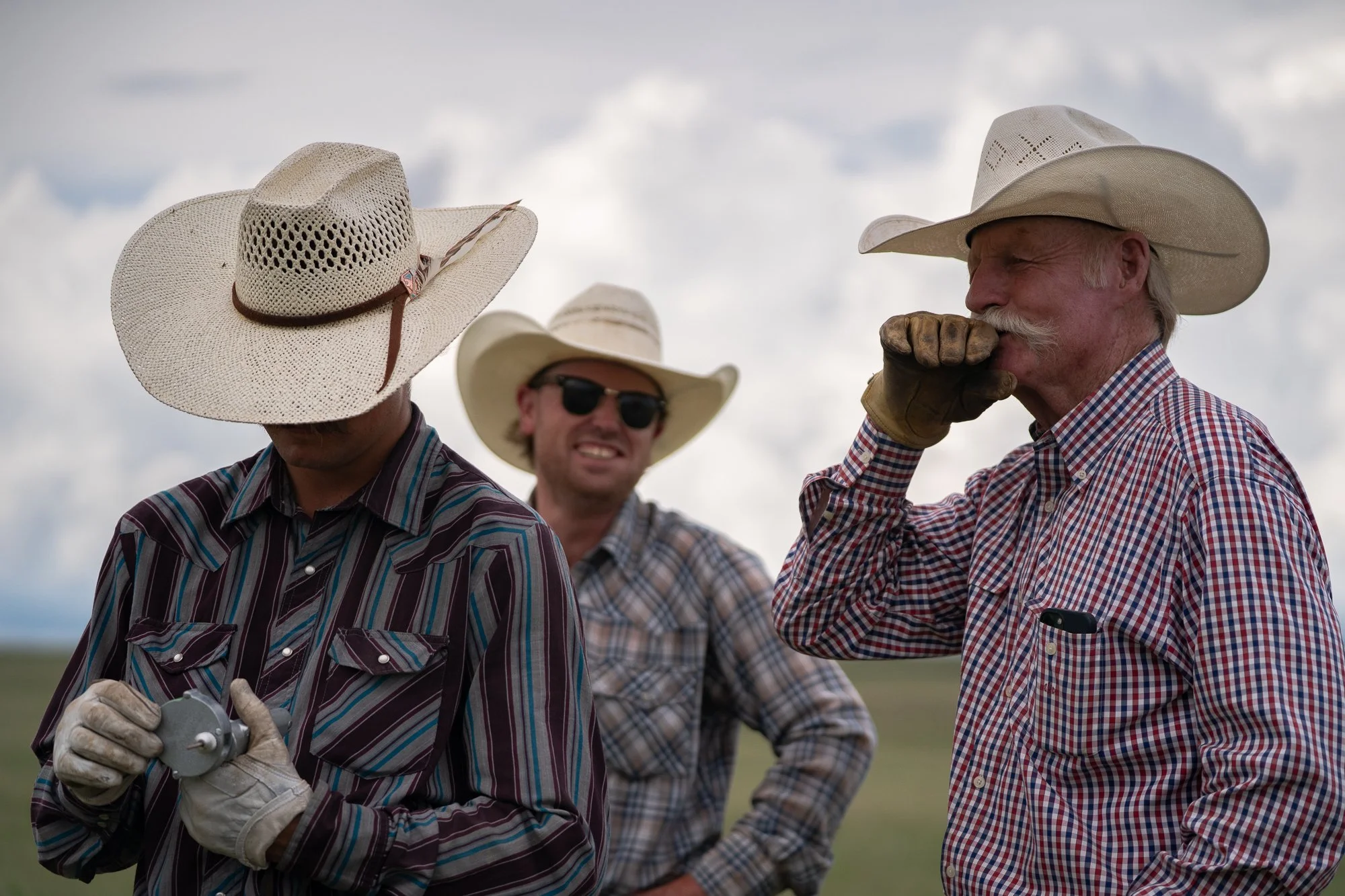 Three cowboys talk together during ranch work in the Nebraska Sandhills at Haythorn Ranch.