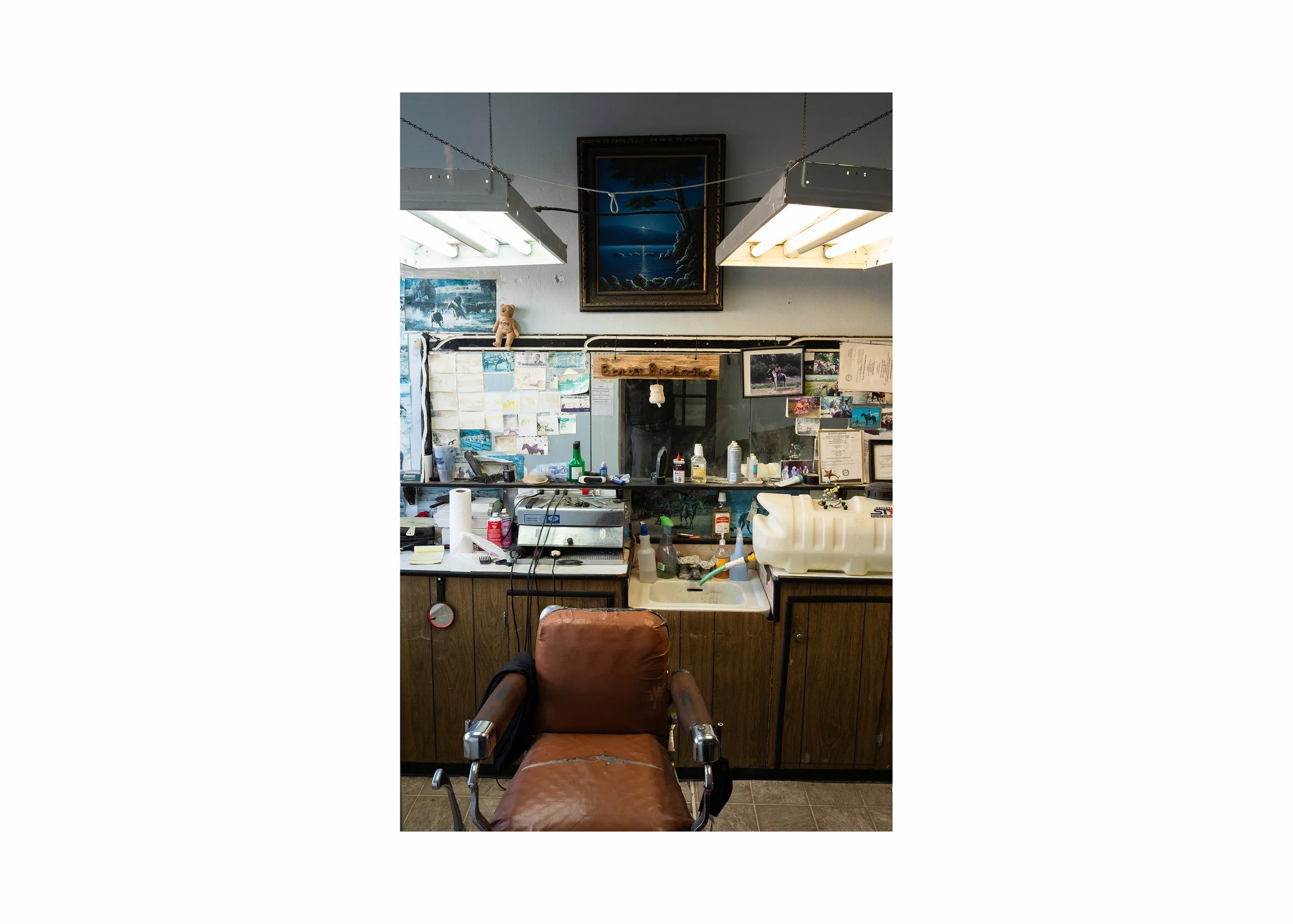 Interior view of a traditional American barbershop with a worn leather chair and supplies