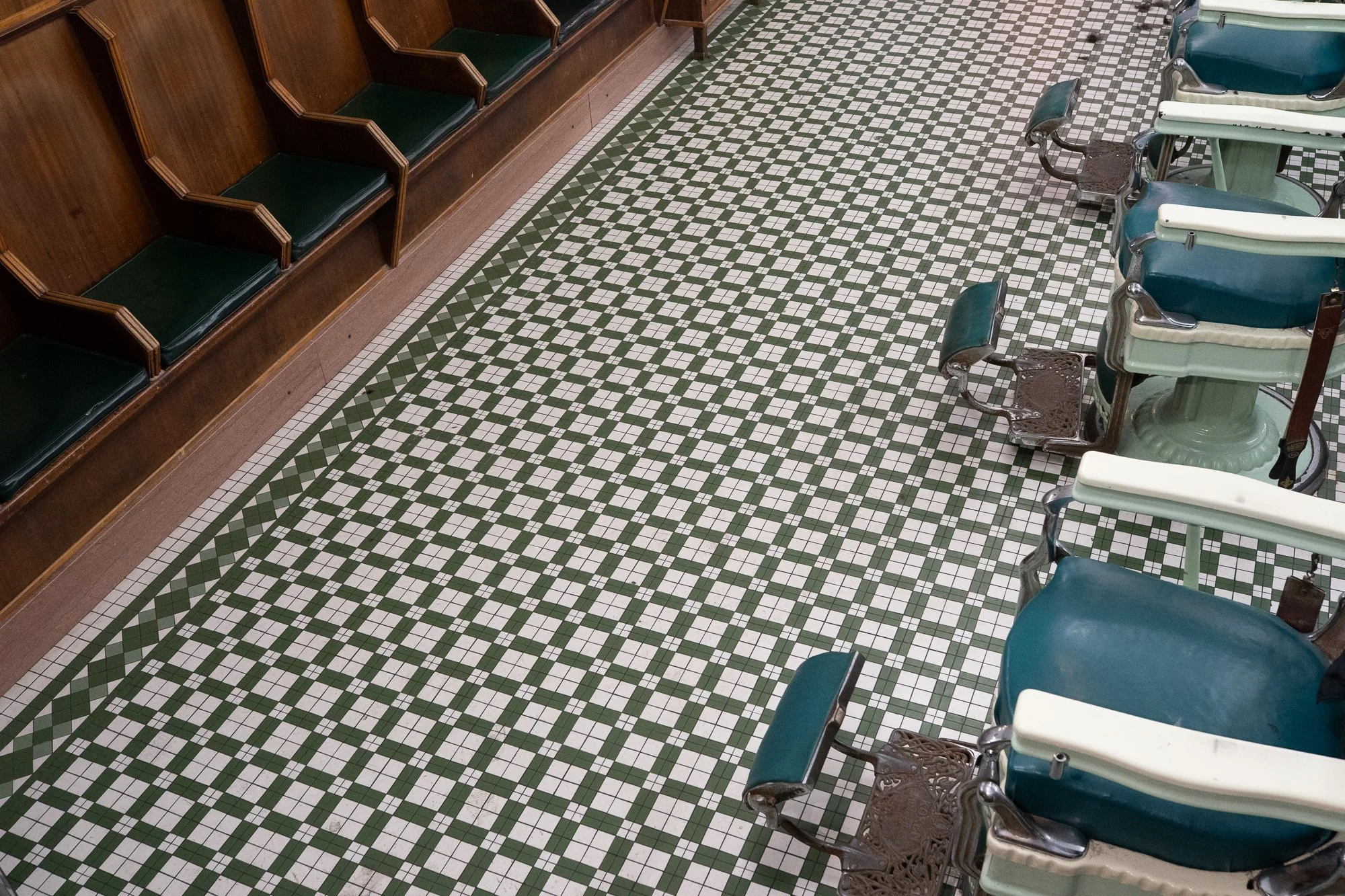 Green and white tile floor with vintage barber chairs at Patsy’s Barbershop in Albany New York