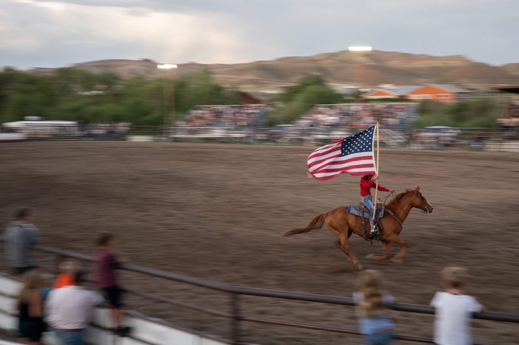 Flag rider carries the American flag around the rodeo arena before the evening events at the Dubois Rodeo in Wyoming