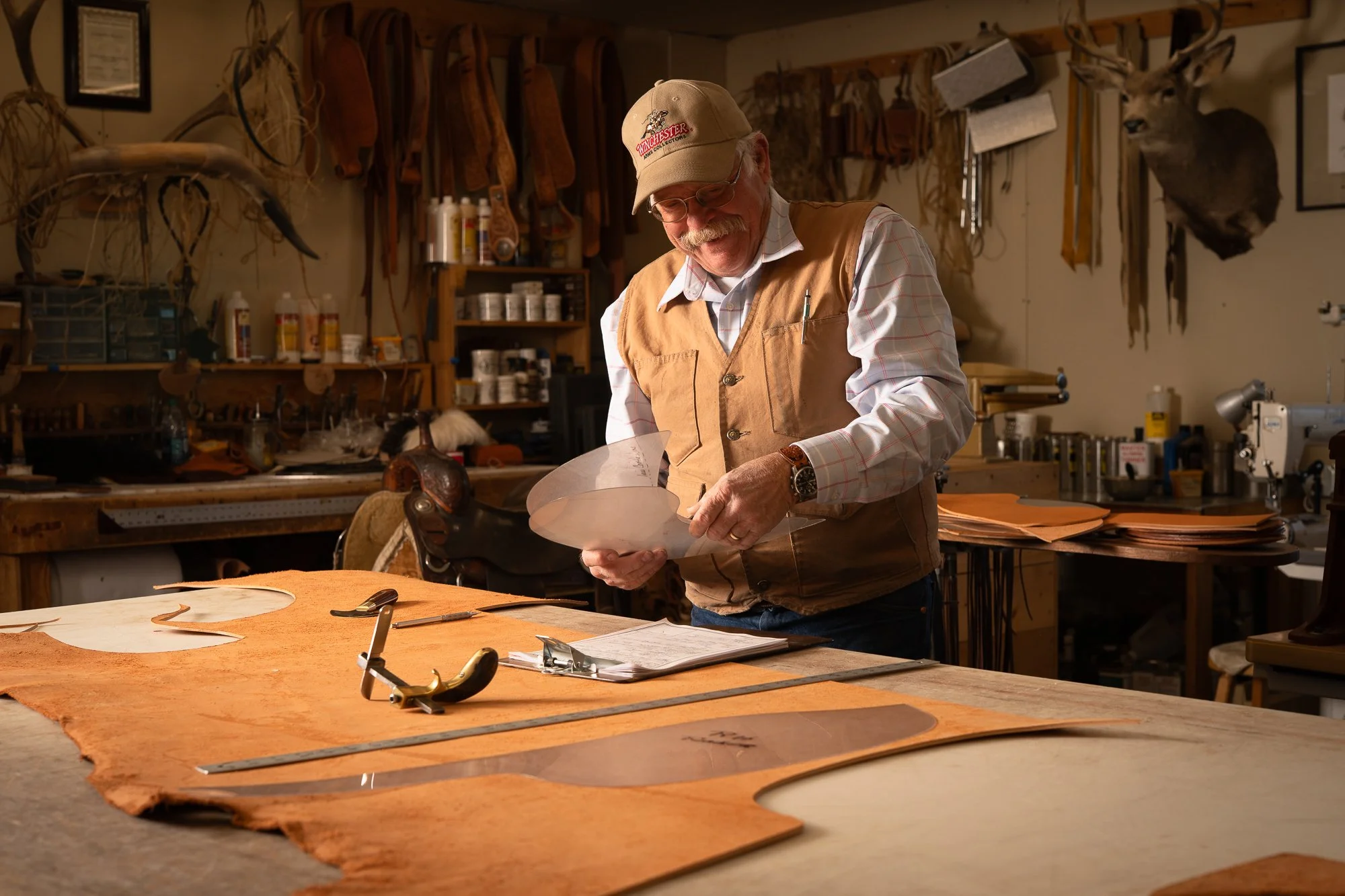 Doug Cox examining leather patterns for a Mother Hubbard saddle in his workshop.