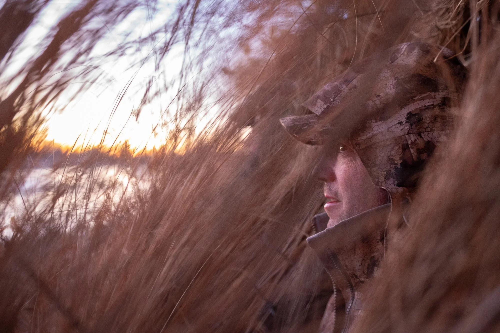A hunting guide stands inside a duck blind during a waterfowl hunt.