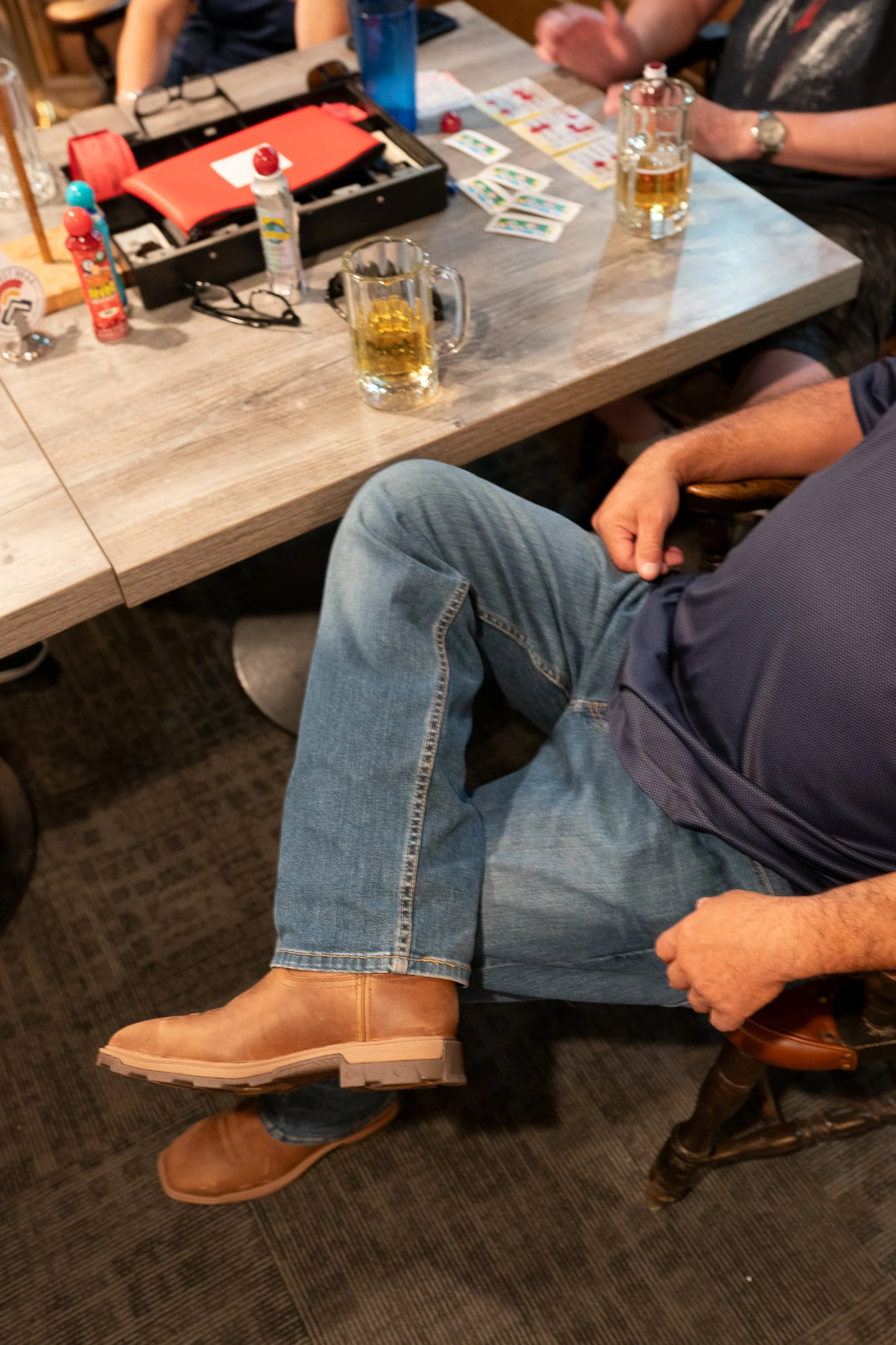 Close detail of Twisted X boots worn under a table inside a VFW hall during a veterans brand campaign