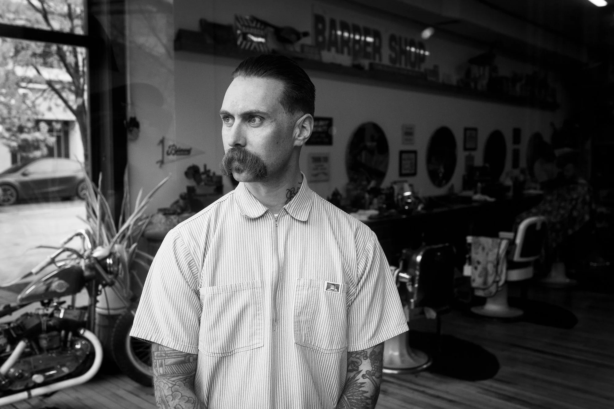 black and white portrait of a barber standing inside Belmont Barbershop in Boise Idaho