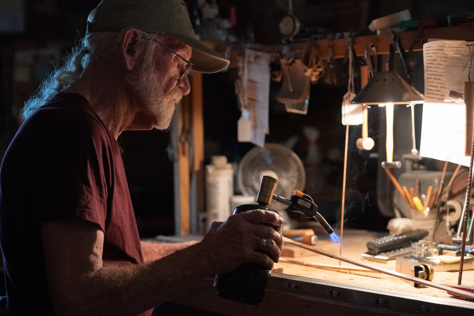 Mike Clark uses a small torch while working on bamboo at his rod-building bench.