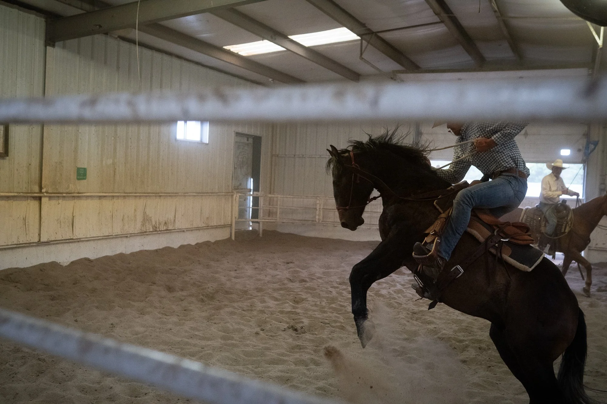 Cowboy riding a horse during training inside an arena at Haythorn Ranch in Nebraska.