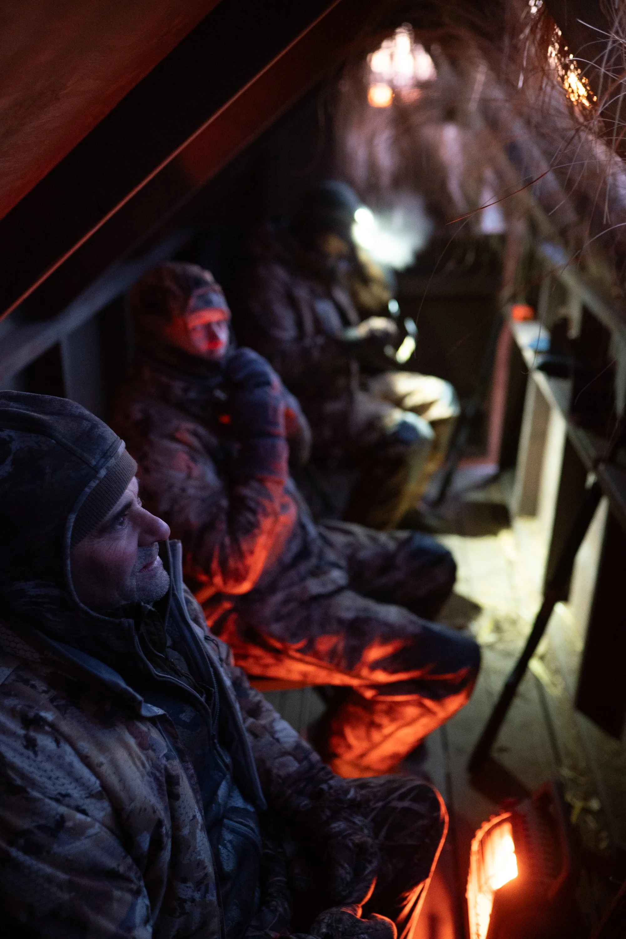 Duck hunters wait inside a blind before sunrise during a Nebraska marsh hunt