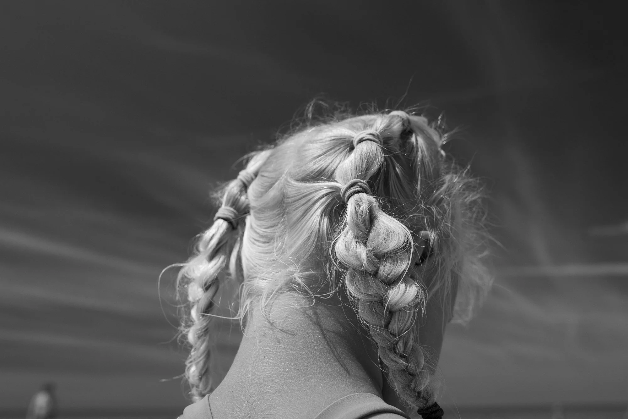 Black and white close-up of a child with braided hair at the beach on Cape Cod