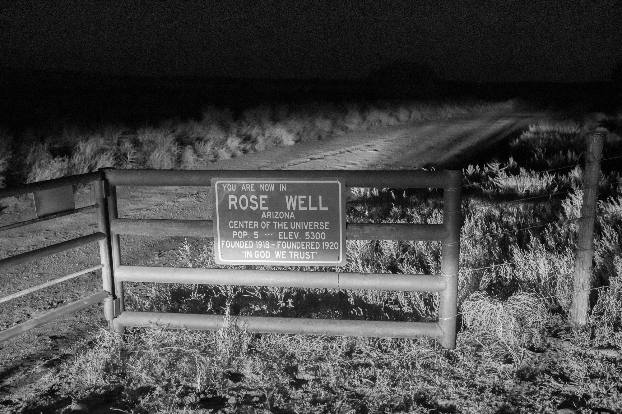 Rose Well Arizona ranch entrance sign photographed at night in the desert