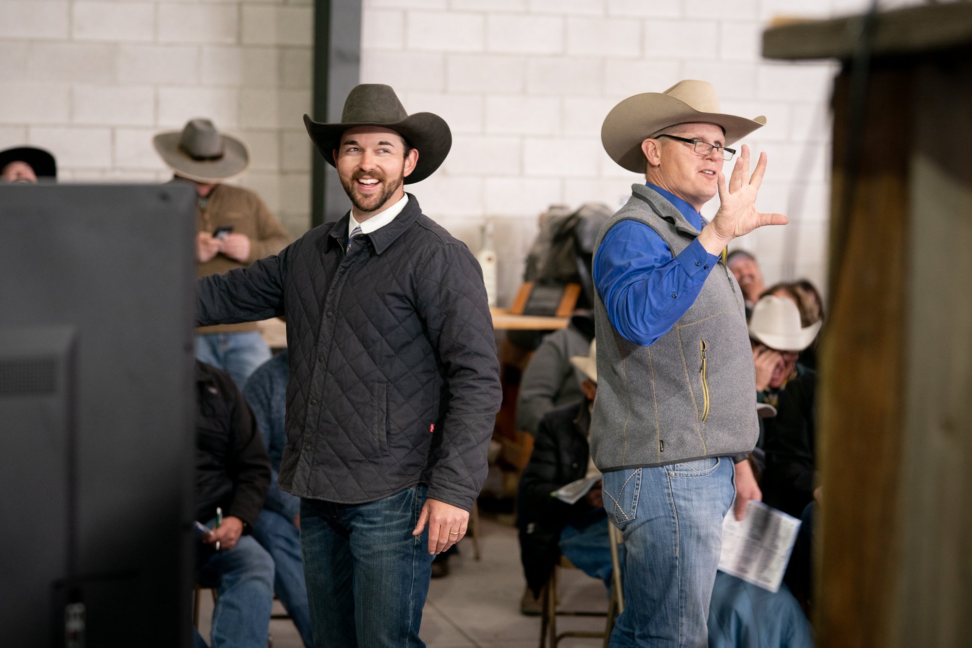 Auctioneer calling bids beside another man in a cowboy hat during a Nevada bull sale