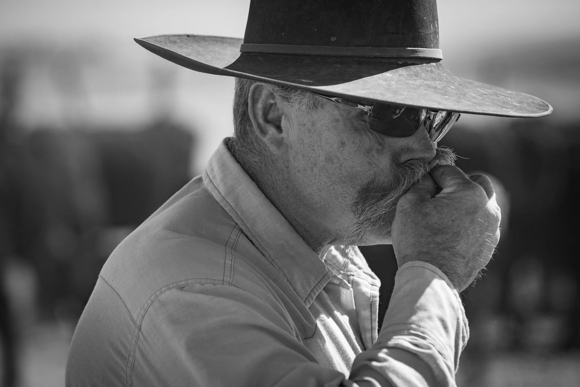 Black and white portrait of a cowboy in a hat and sunglasses at the Diamond A Ranch