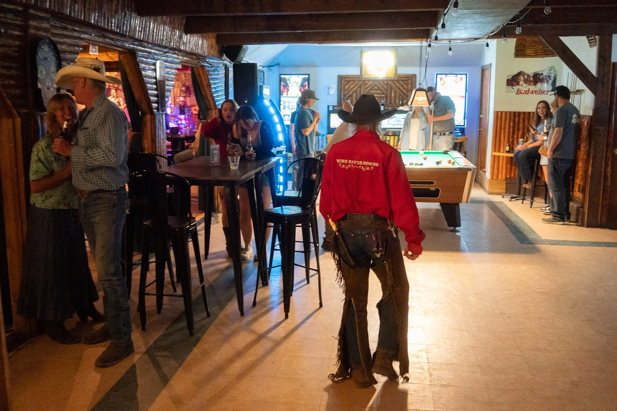 Cowboy wearing a Wind River Rodeo shirt walks through the Rustic Pine Tavern in Dubois Wyoming