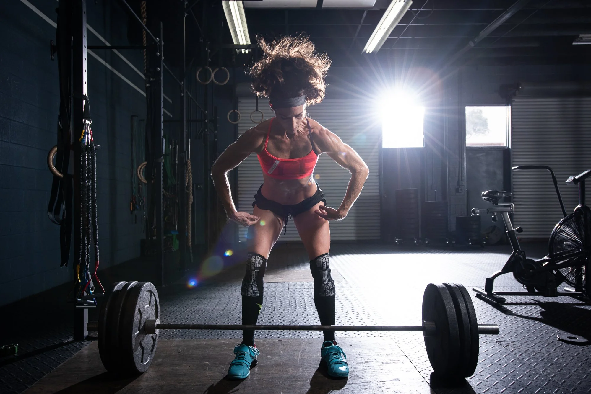 Female athlete preparing to lift barbell in gym focusing on form and stance