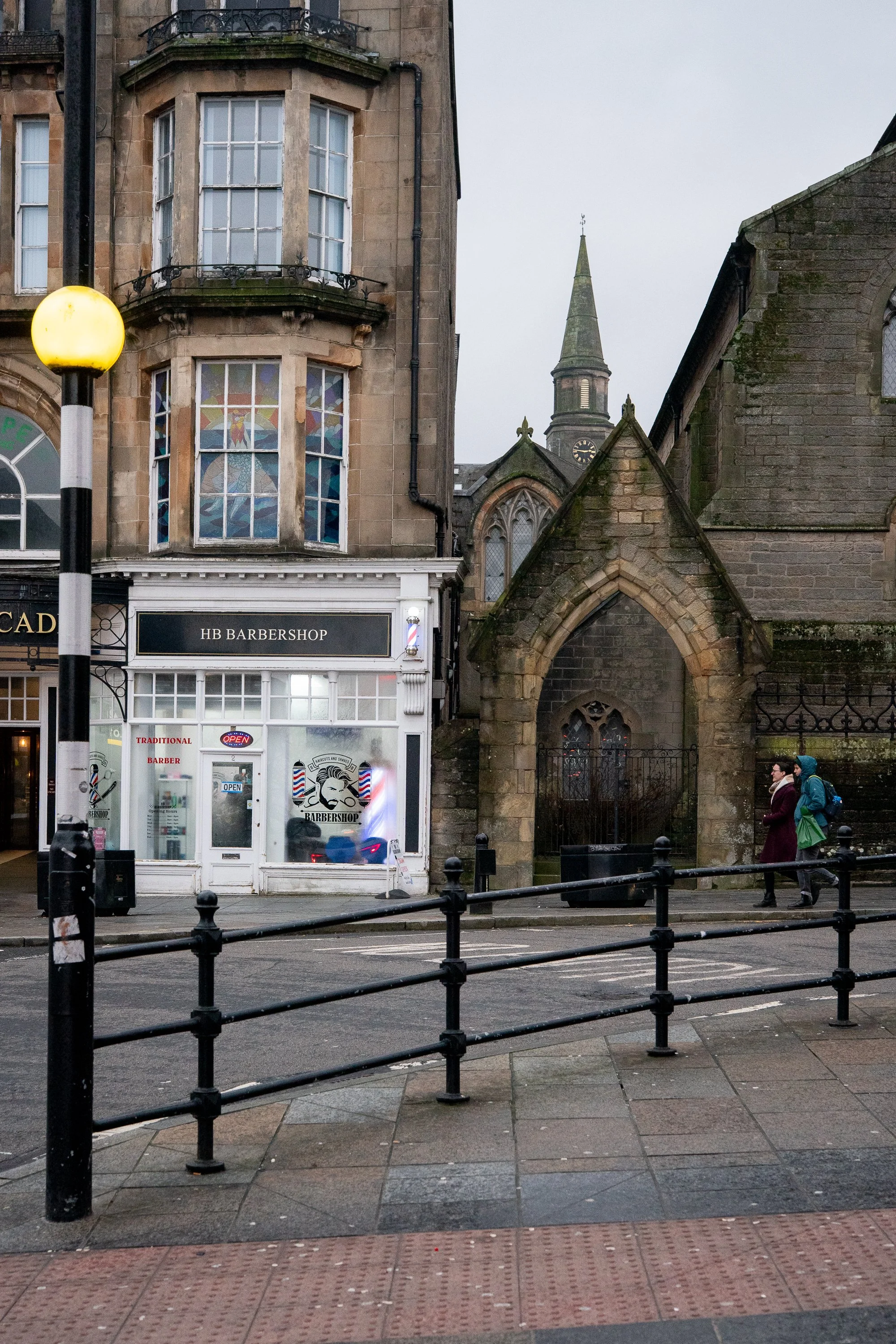 hb barber shop next to historic stone church in scotland street scene