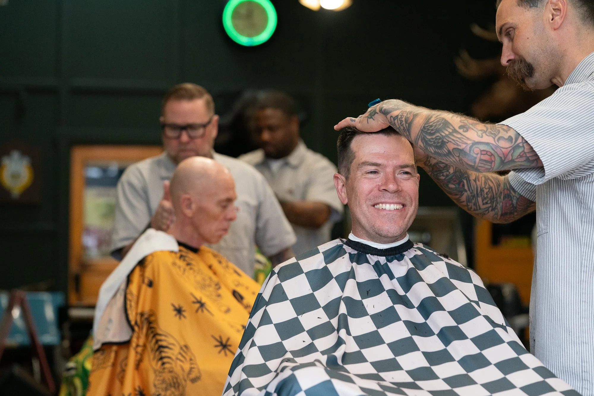 smiling client getting a haircut inside Belmont Barbershop in Boise Idaho