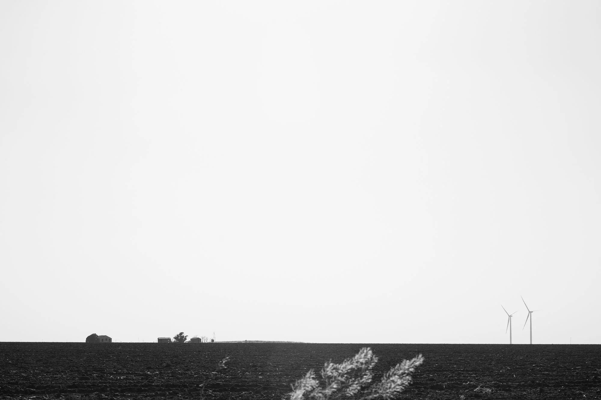 Minimal black and white landscape with distant wind turbines on the Llano Estacado