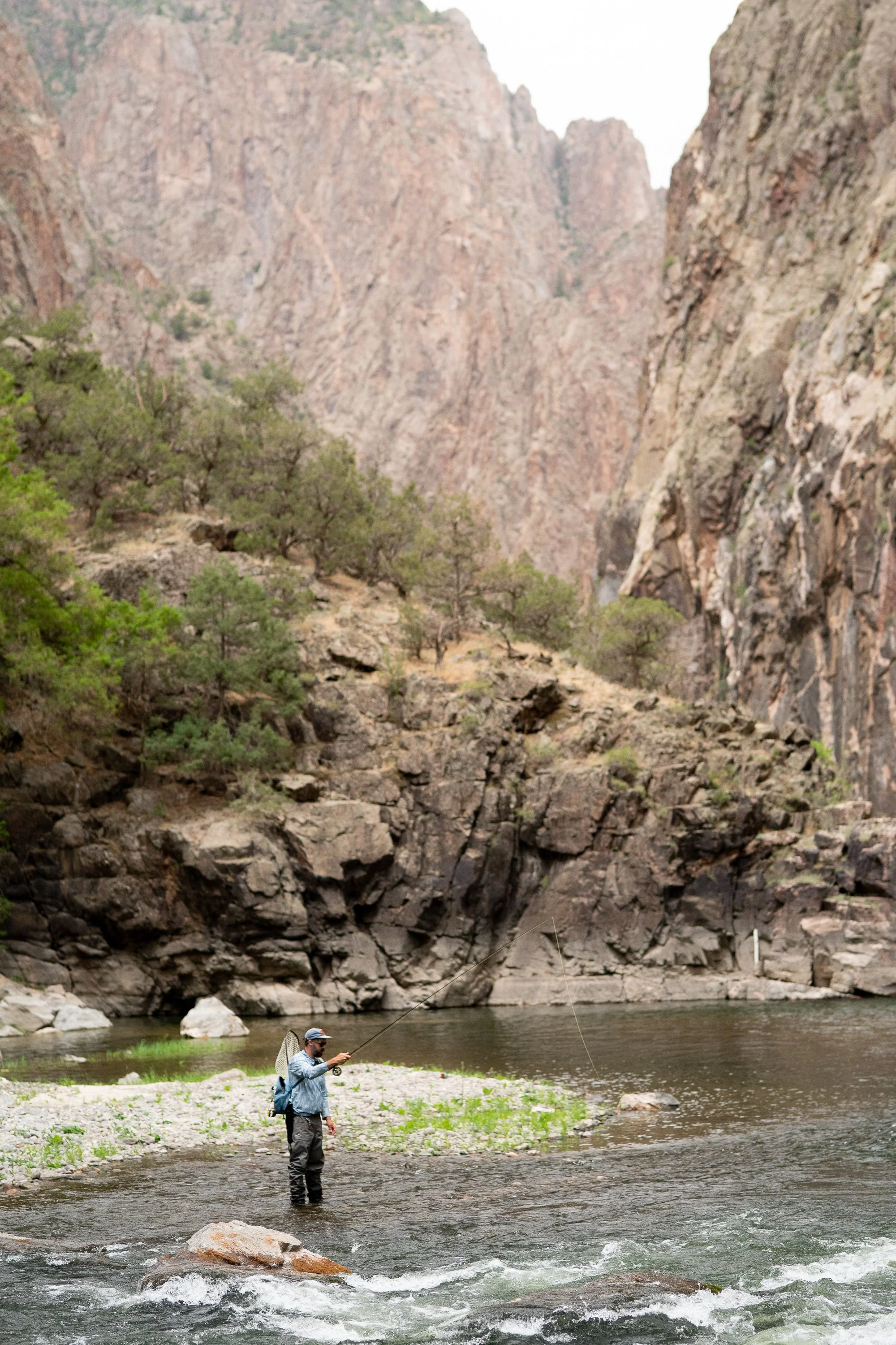 A fly angler fishes the Gunnison River surrounded by steep canyon walls