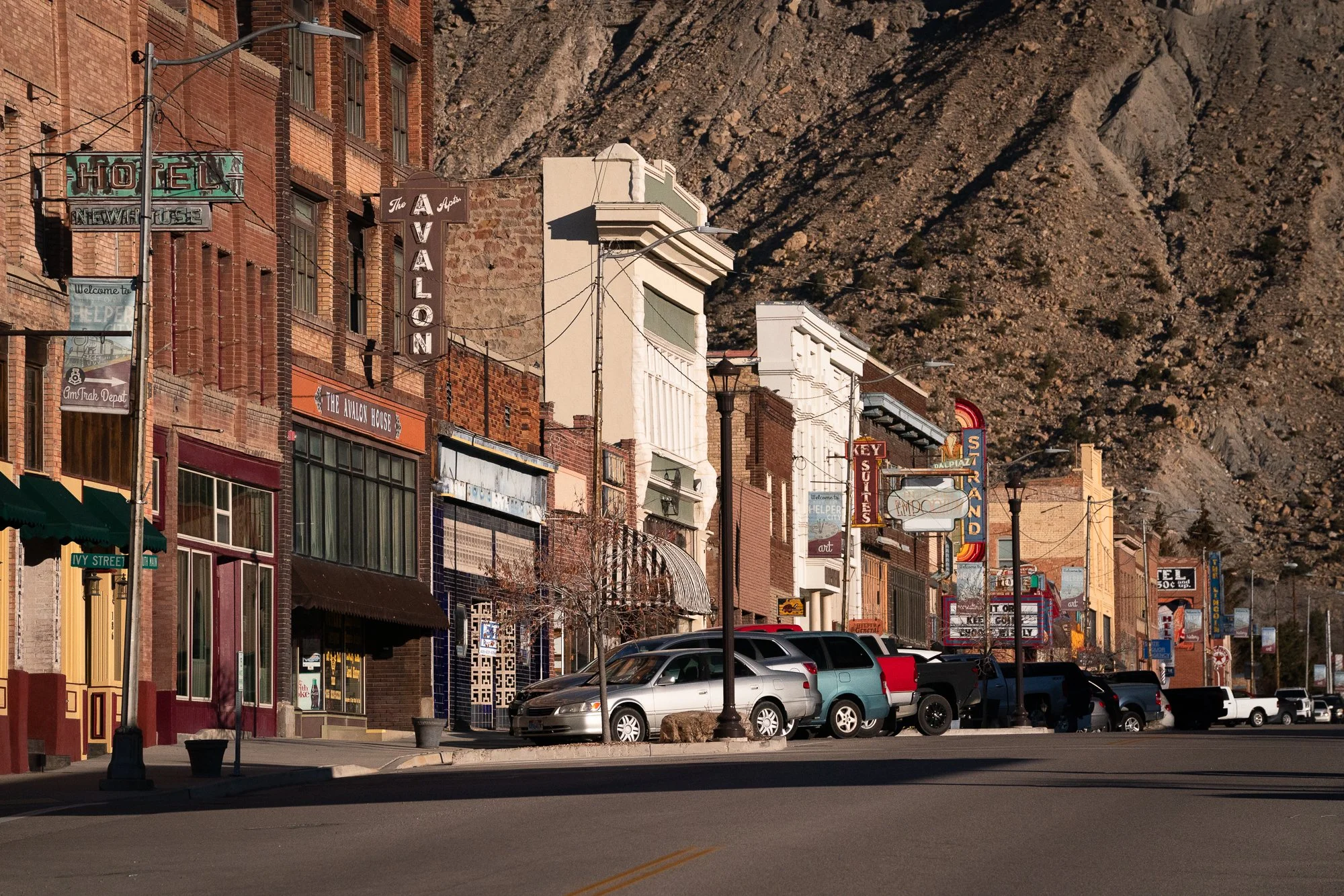 Historic Main Street in Helper Utah with brick buildings and cliffs