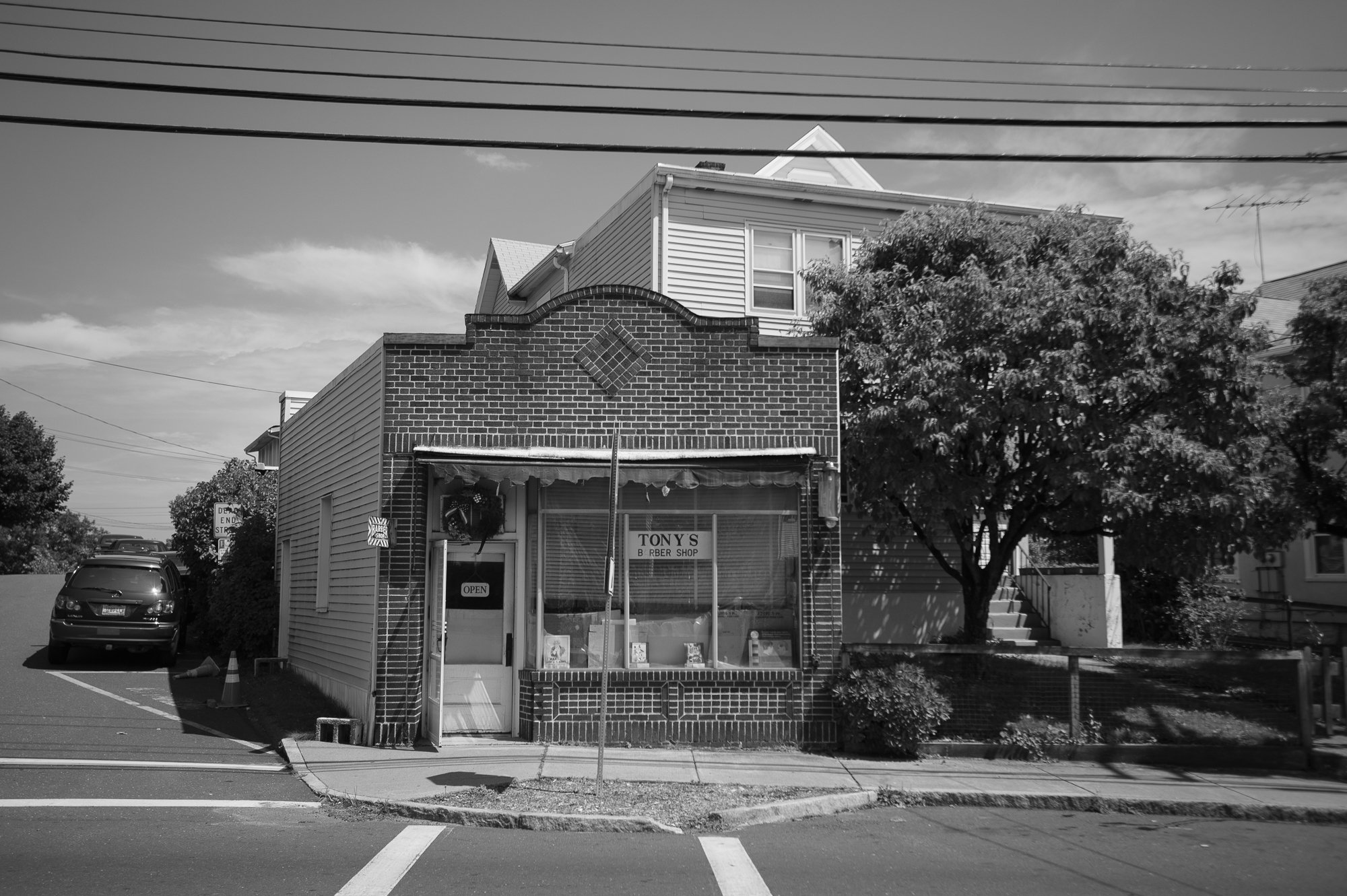 black and white exterior of Tony's Barbershop in Greenwich Connecticut storefront