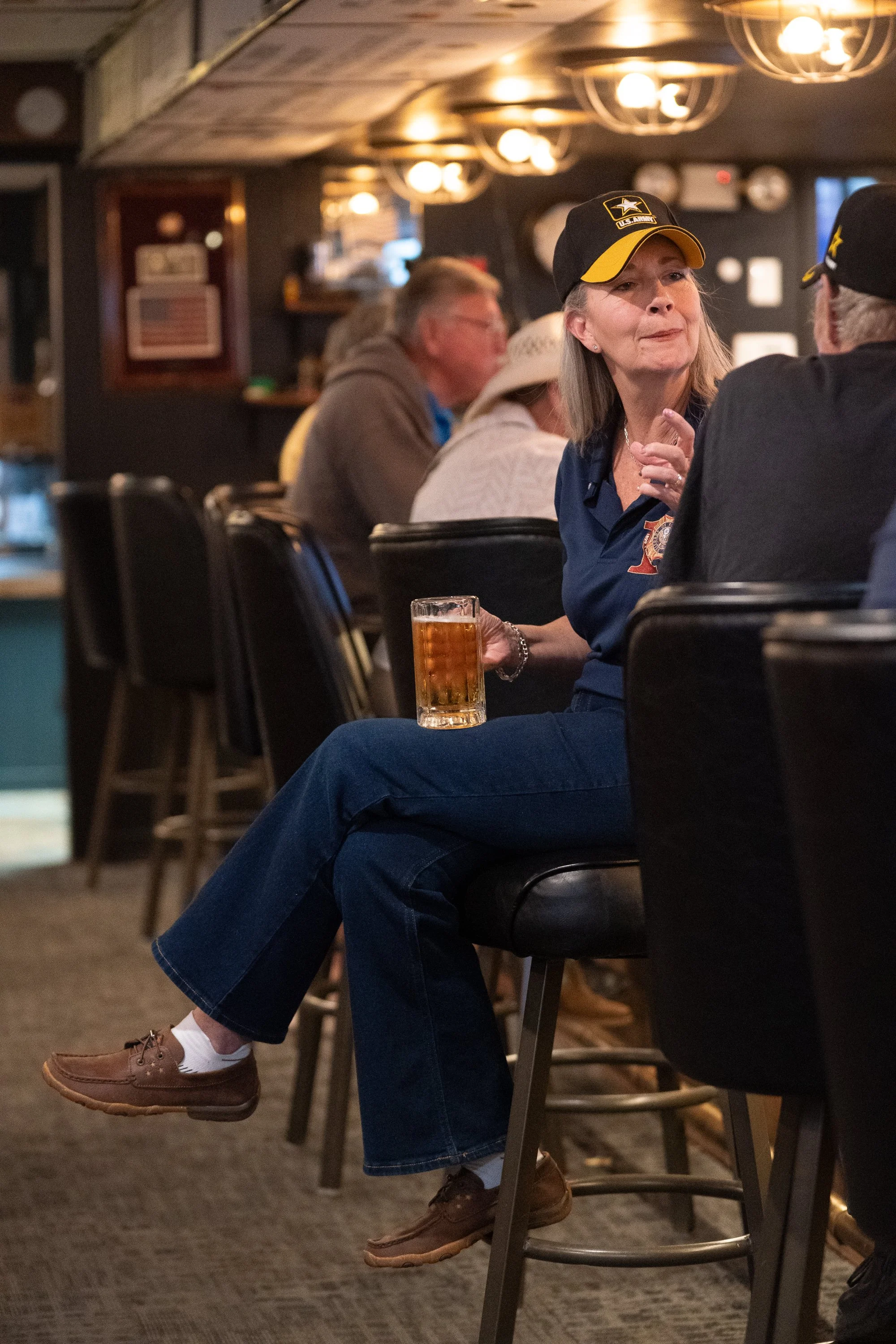 People seated inside a VFW hall with portraits, memorabilia, and community tables