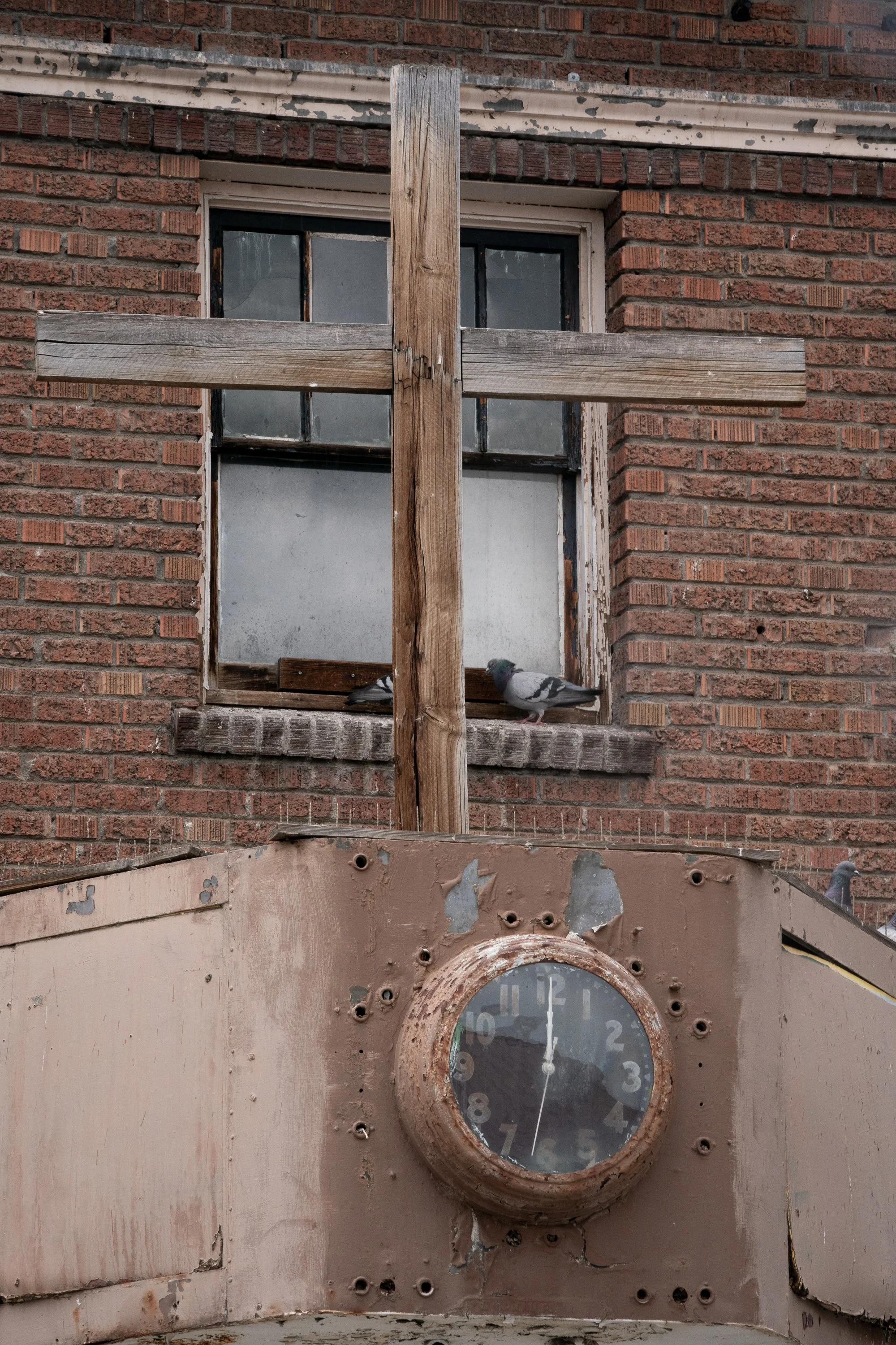 Weathered brick building with an old clock and boarded window in Wyoming