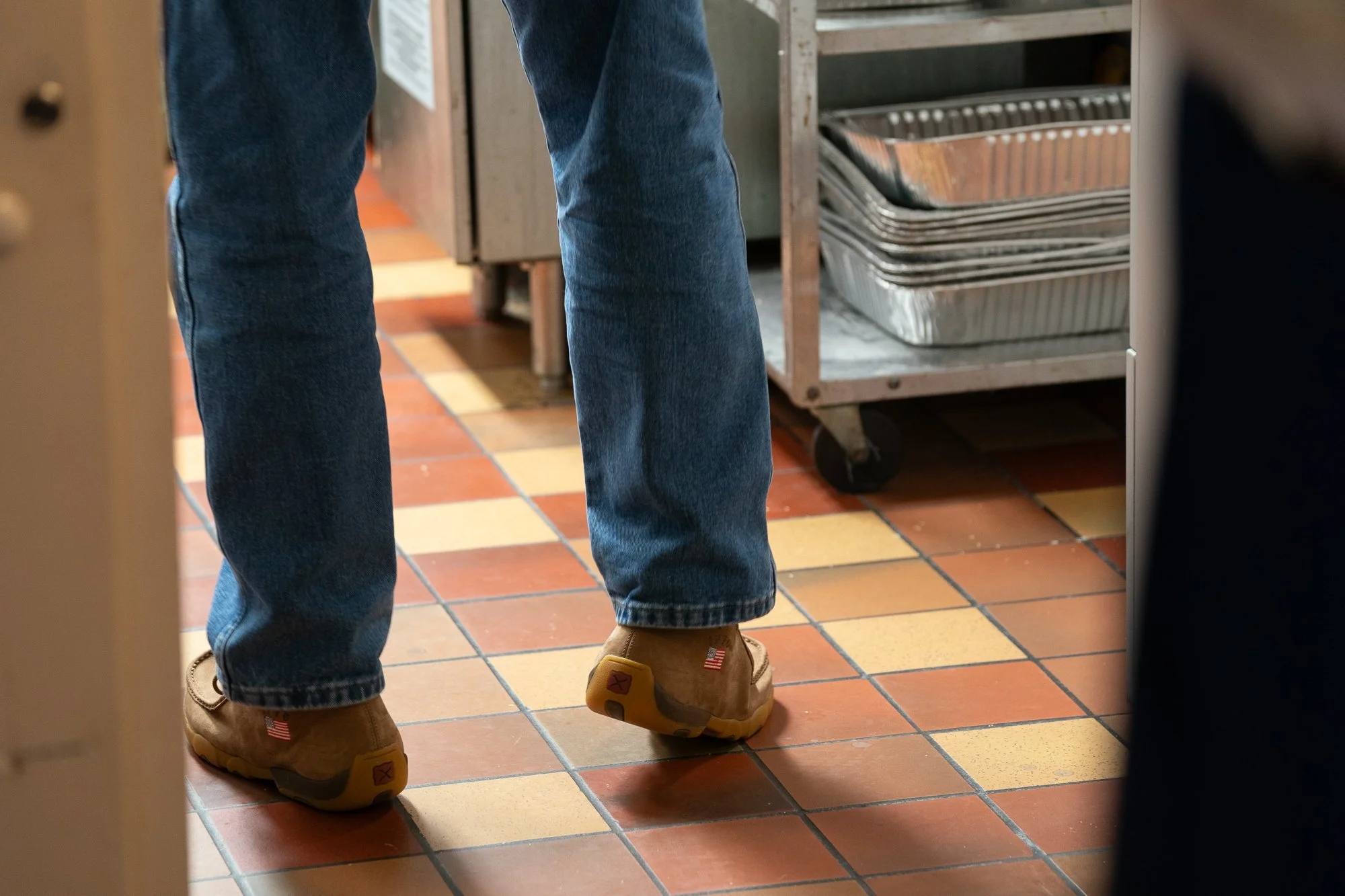 Twisted X boots worn with jeans on a tile floor during a veterans brand campaign