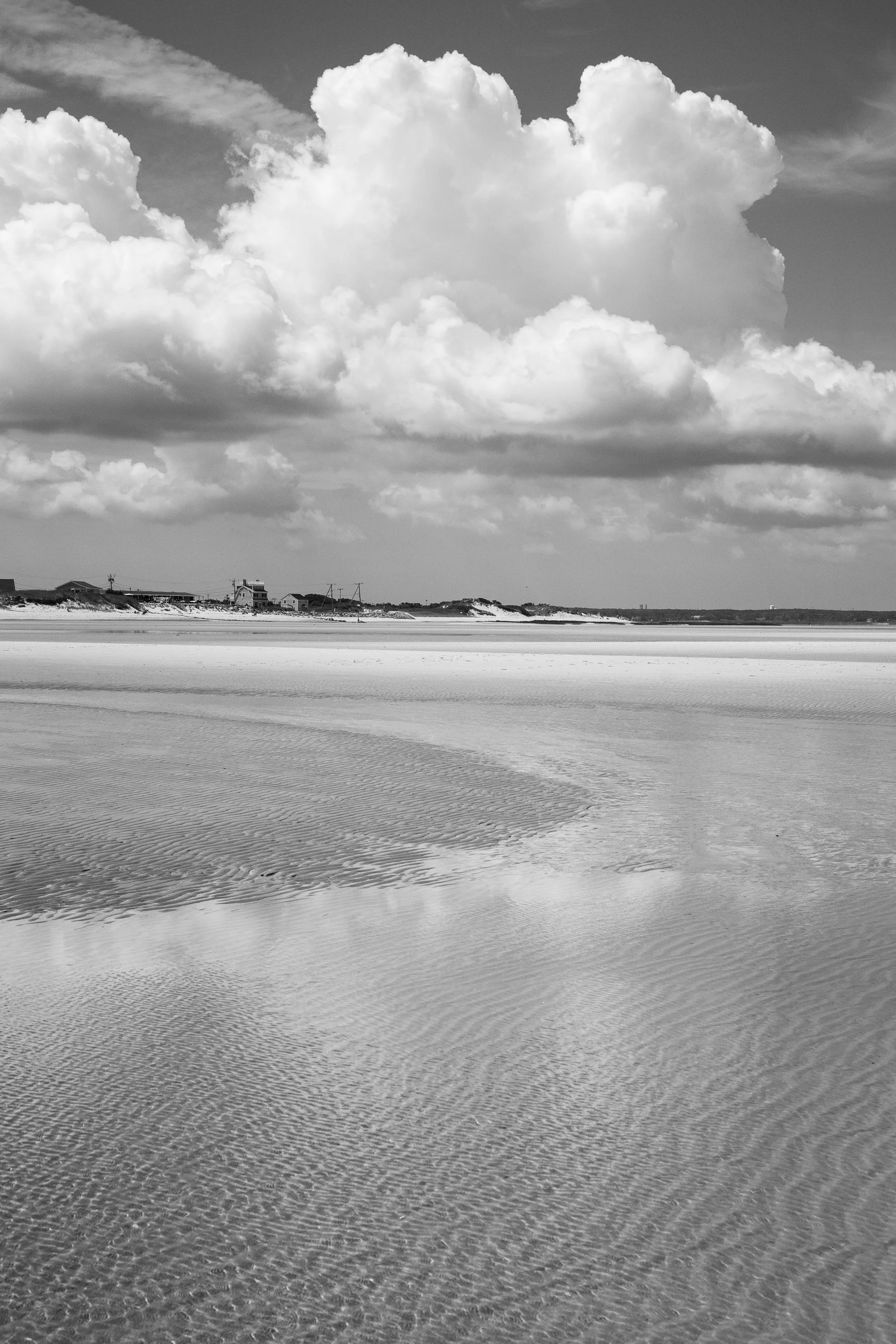 Black and white photo of Cape Cod sandbars and tidal flats with rippled textures and distant coastline