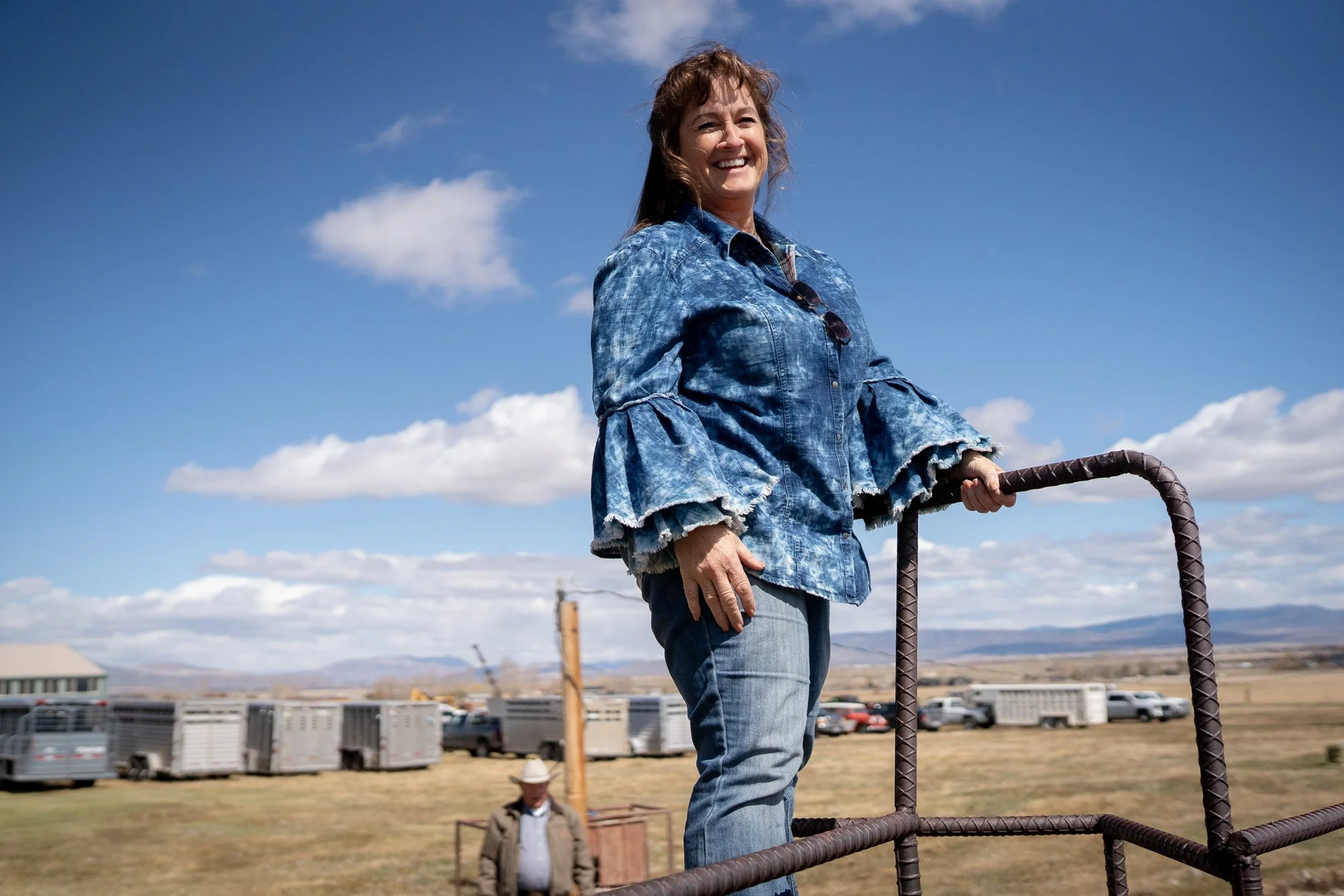 Woman standing on a cattle pen rail at a Nevada bull sale