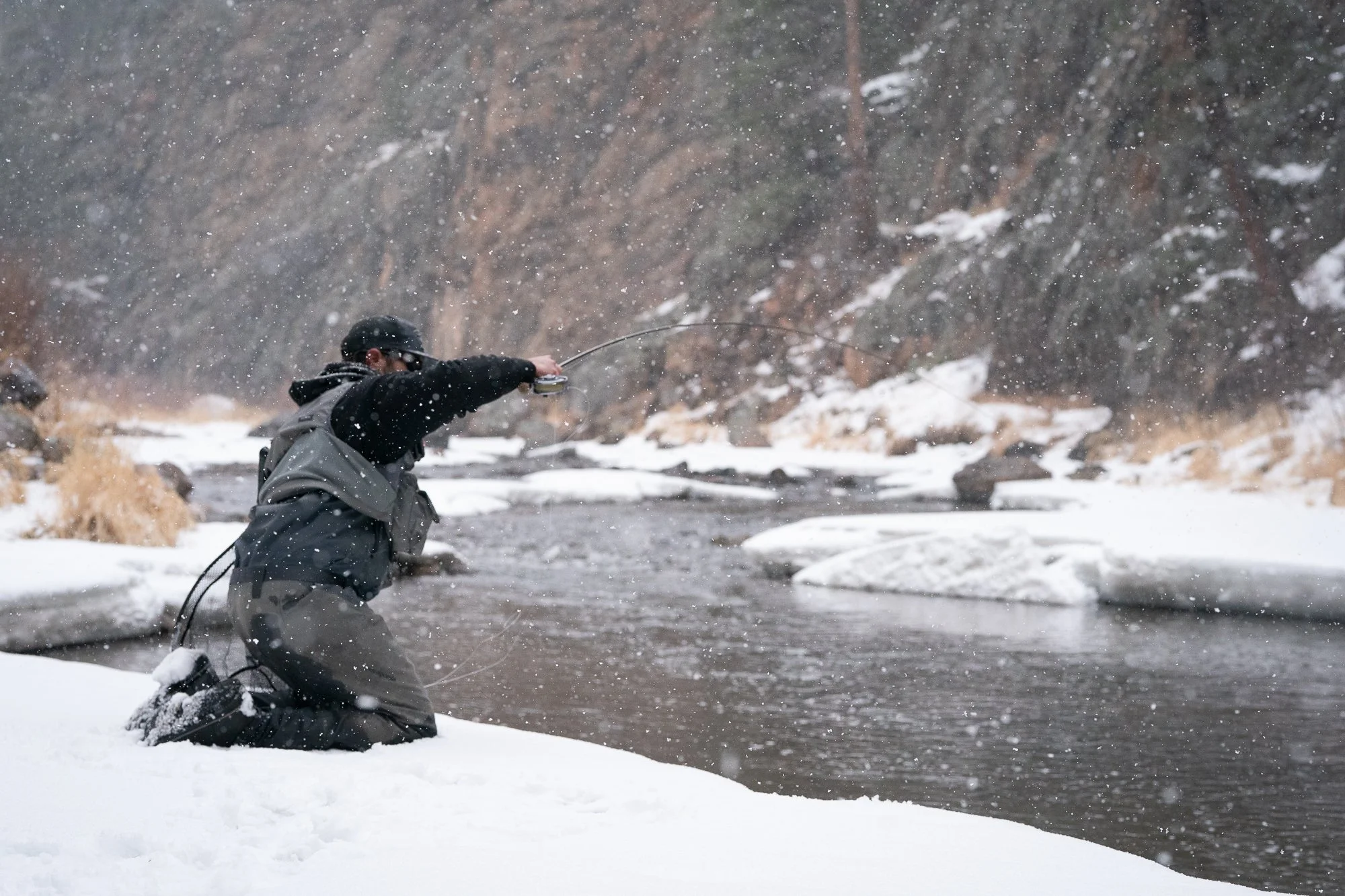 Photograph of a fly fisherman in a snowstorm in Colorado near Estes Park