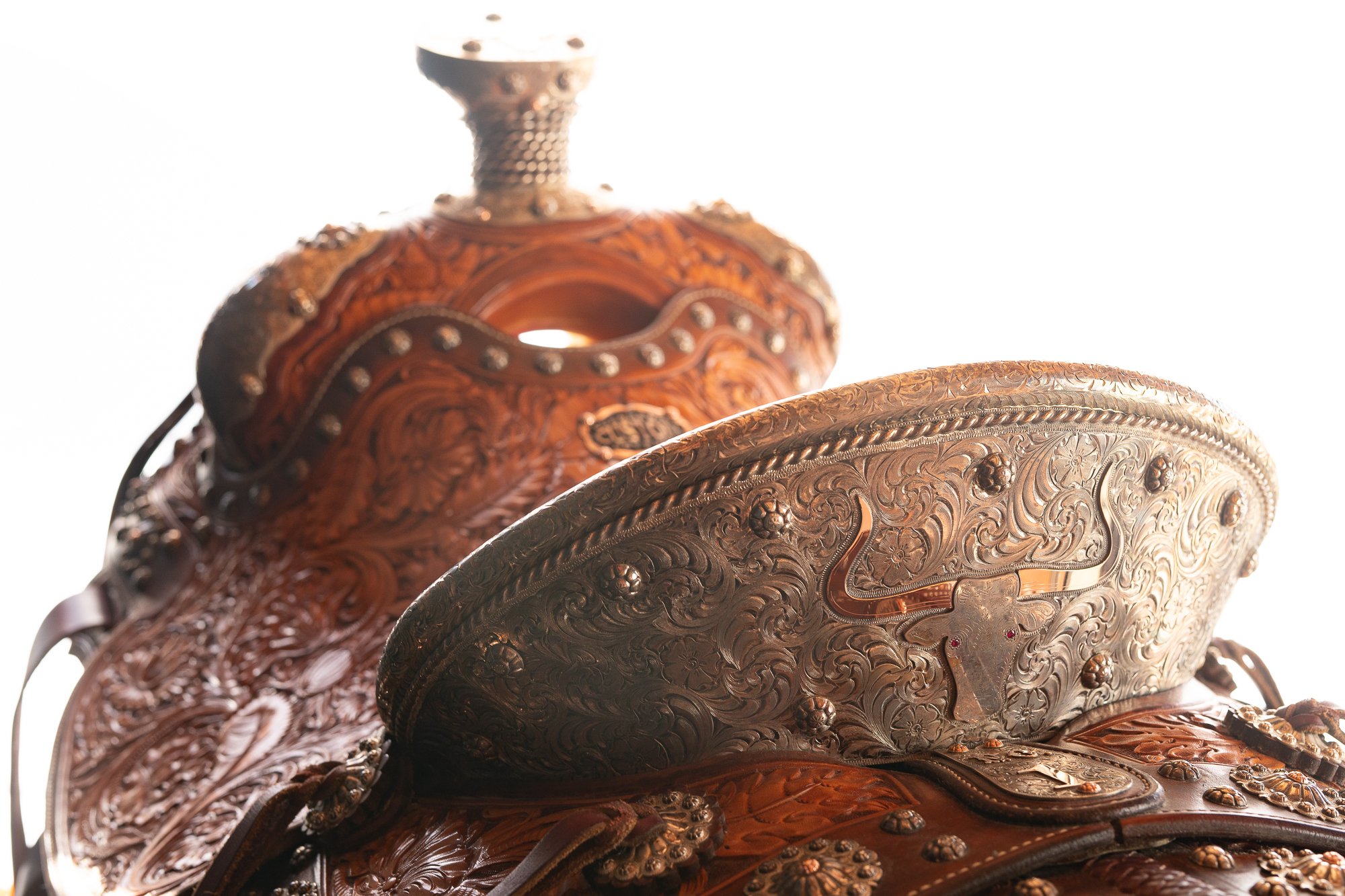 Silver-mounted Western saddle with engraved metal and hand-tooled leather