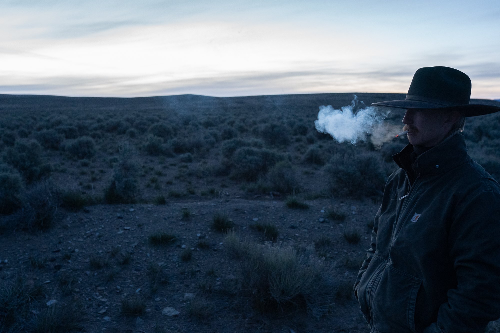 A cowboy smokes while standing in the high desert near the ZX Ranch in southeastern Oregon