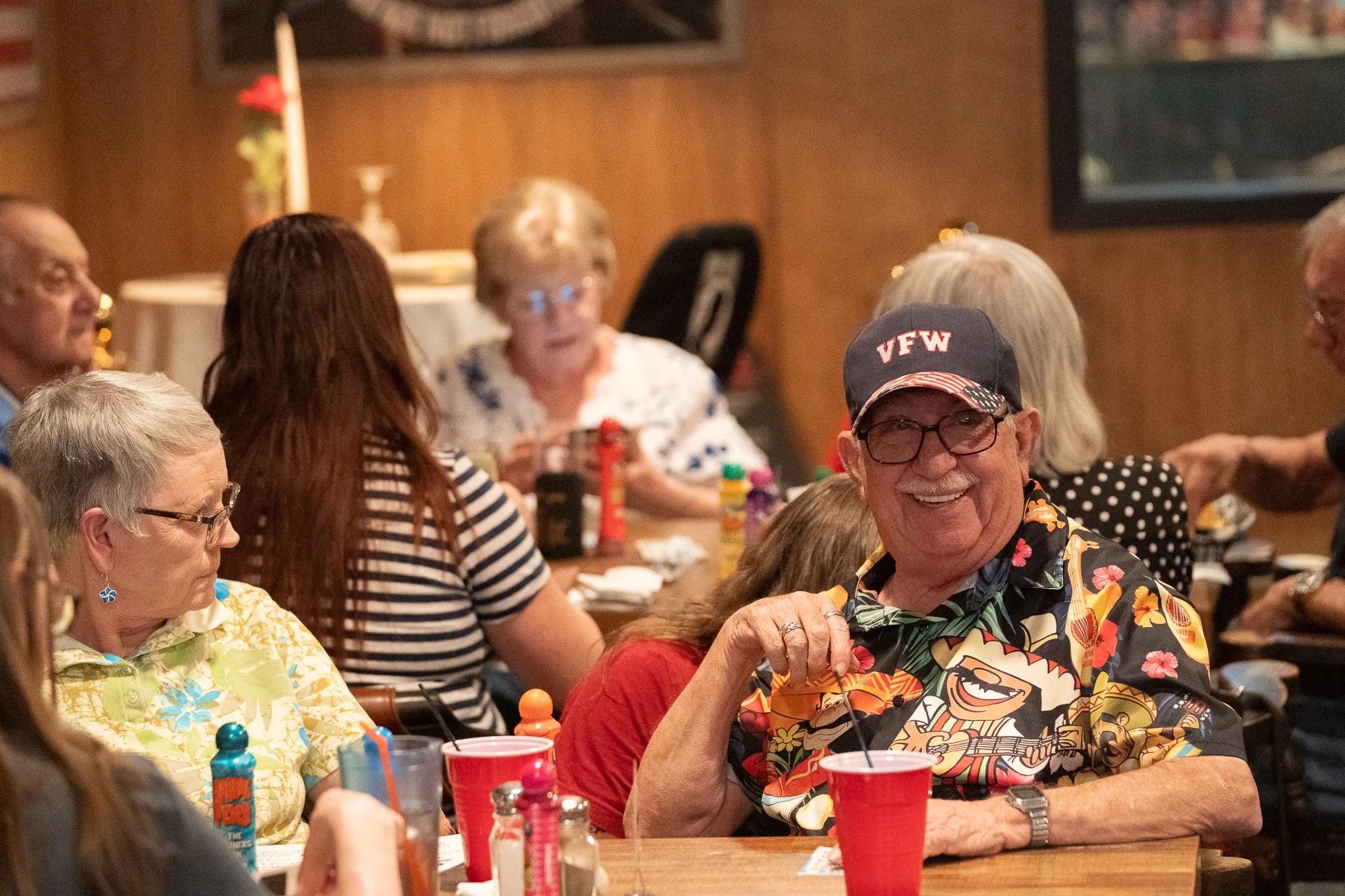 Veterans and community members seated at tables inside a VFW hall during a brand photography campaign